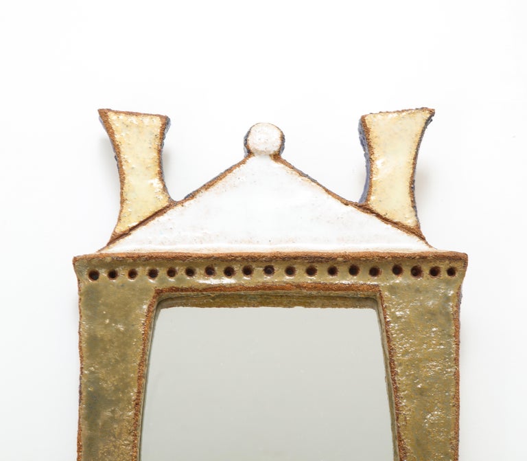 Rare enameled ceramic mirror by Les Argonautes, France, c. 1960 (Signed) 

This delightful mirror was made by Isabelle Ferlay and Frédérique Bourget, the acclaimed design duo behind Atelier Les Argonautes. The rare model is beautifully uncanny in