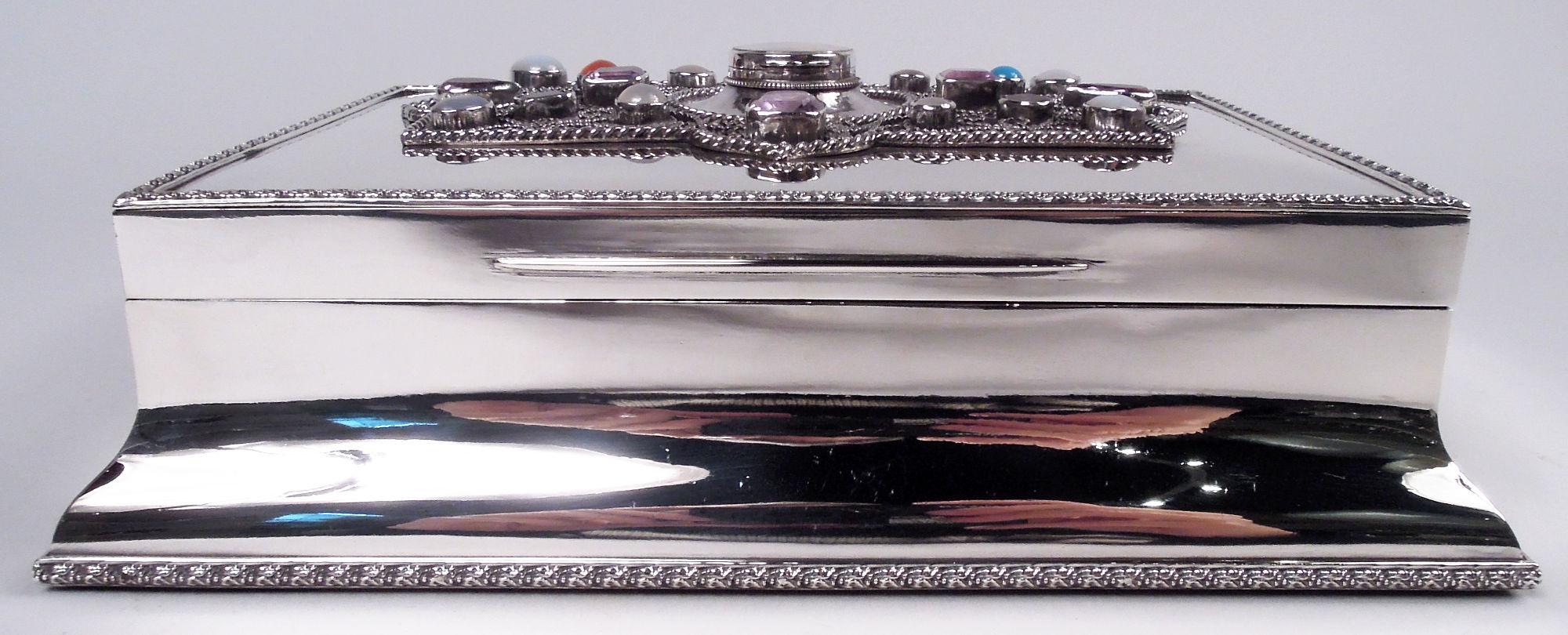 Rara caja eduardiana clásica de plata de ley. Fabricado por George Henry Cowell en Londres en 1908. Rectangular con base extendida y tapa abatible. La parte superior de la tapa tenía volutas de cuentas montadas con joyas en una envoltura curvilínea