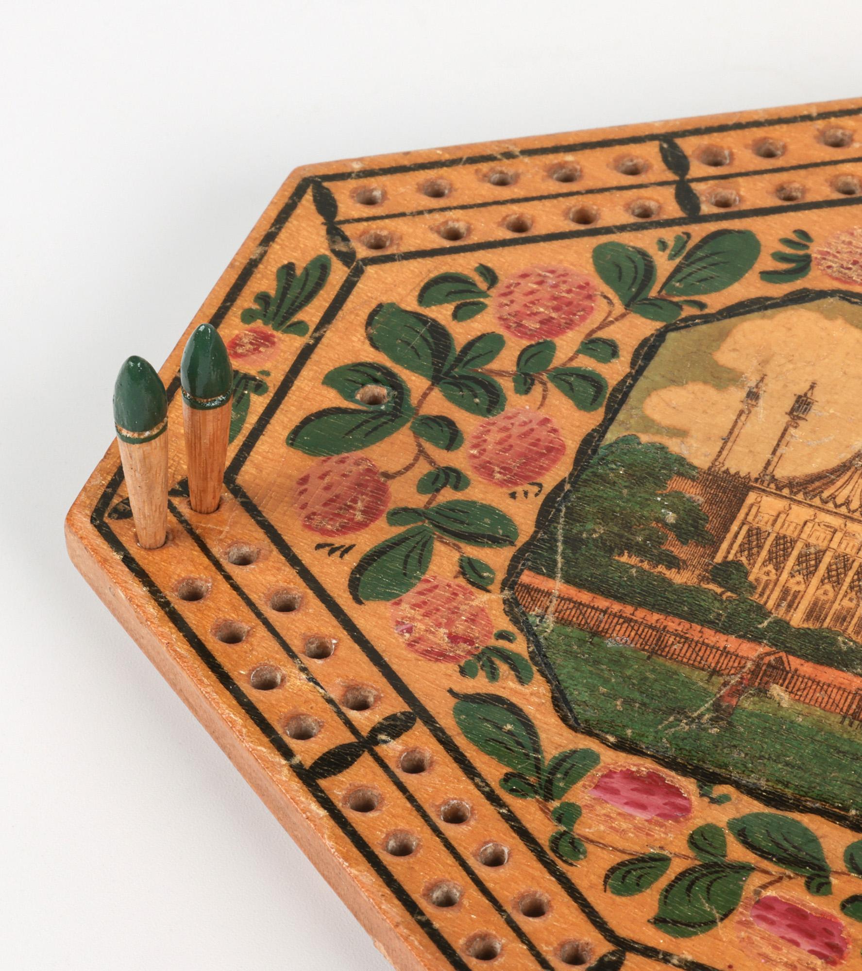 Rare plateau de jeu de cribbage anglais en bois avec une vue du pavillon de Brighton datant du règne de George IV, de 1820 à 1830. Le plateau de forme octogonale repose sur quatre pieds boules d'origine et comporte un compartiment creusé à la base