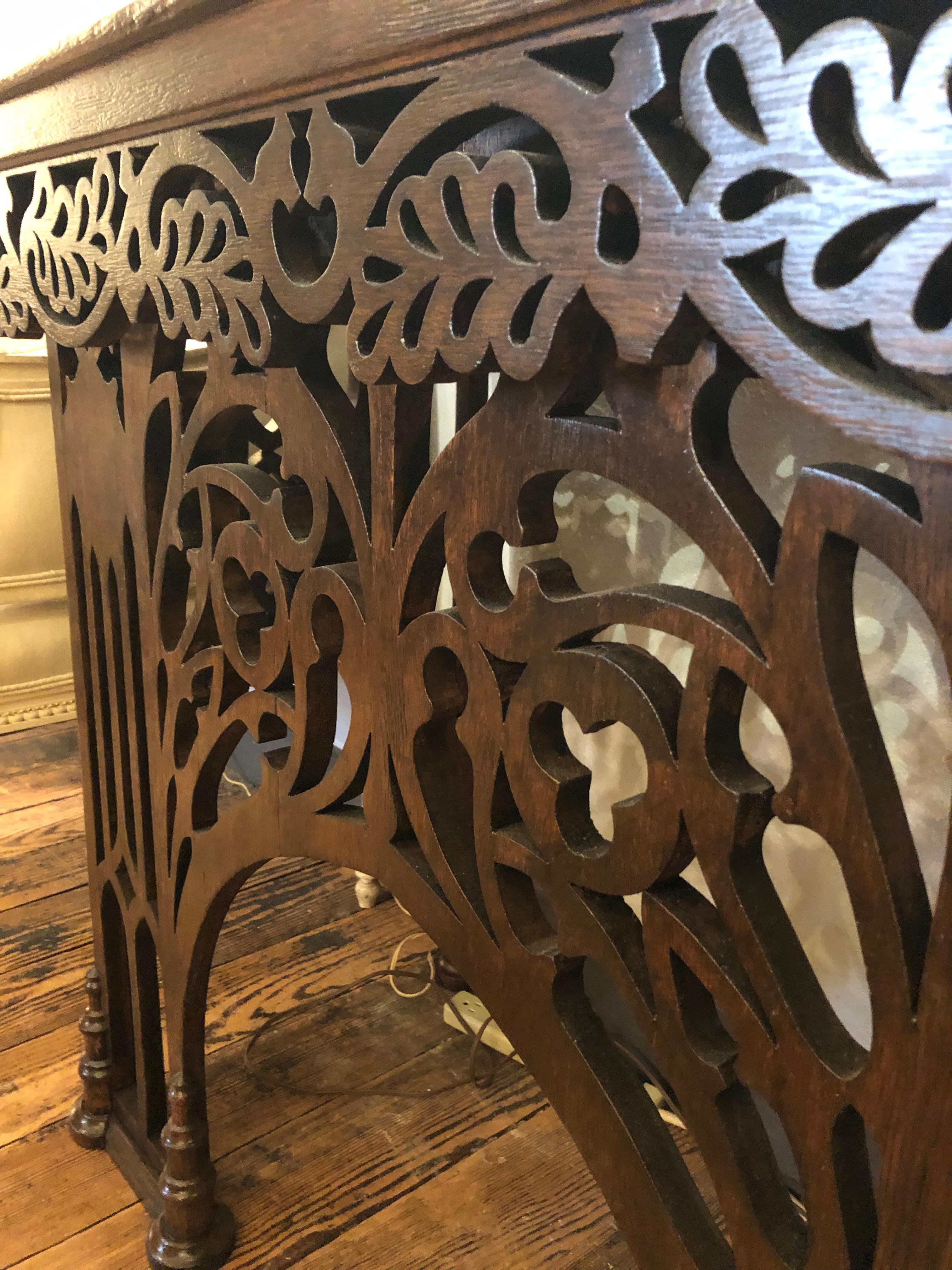 Unusual and gorgeous vintage Gothic Revival console table having rich dark walnut top and amazingly carved fretwork and arches on apron, front and sides.