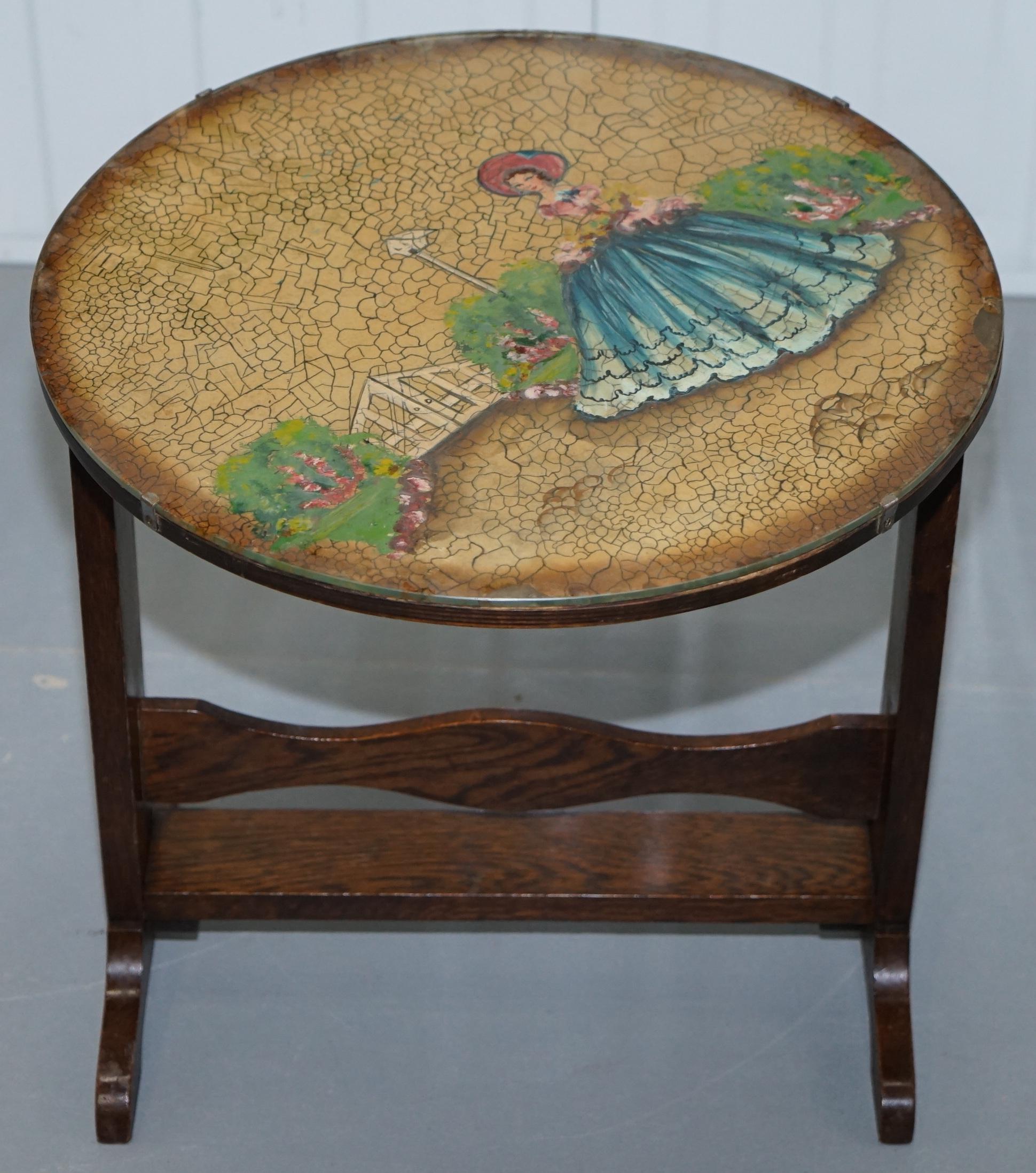 We are delighted to offer for sale this lovely little handmade in England tilt top oak side table with glass cased hand painted picture

A good looking and well-made piece, the pictures have been refitted at the wrong angle which can be realigned
