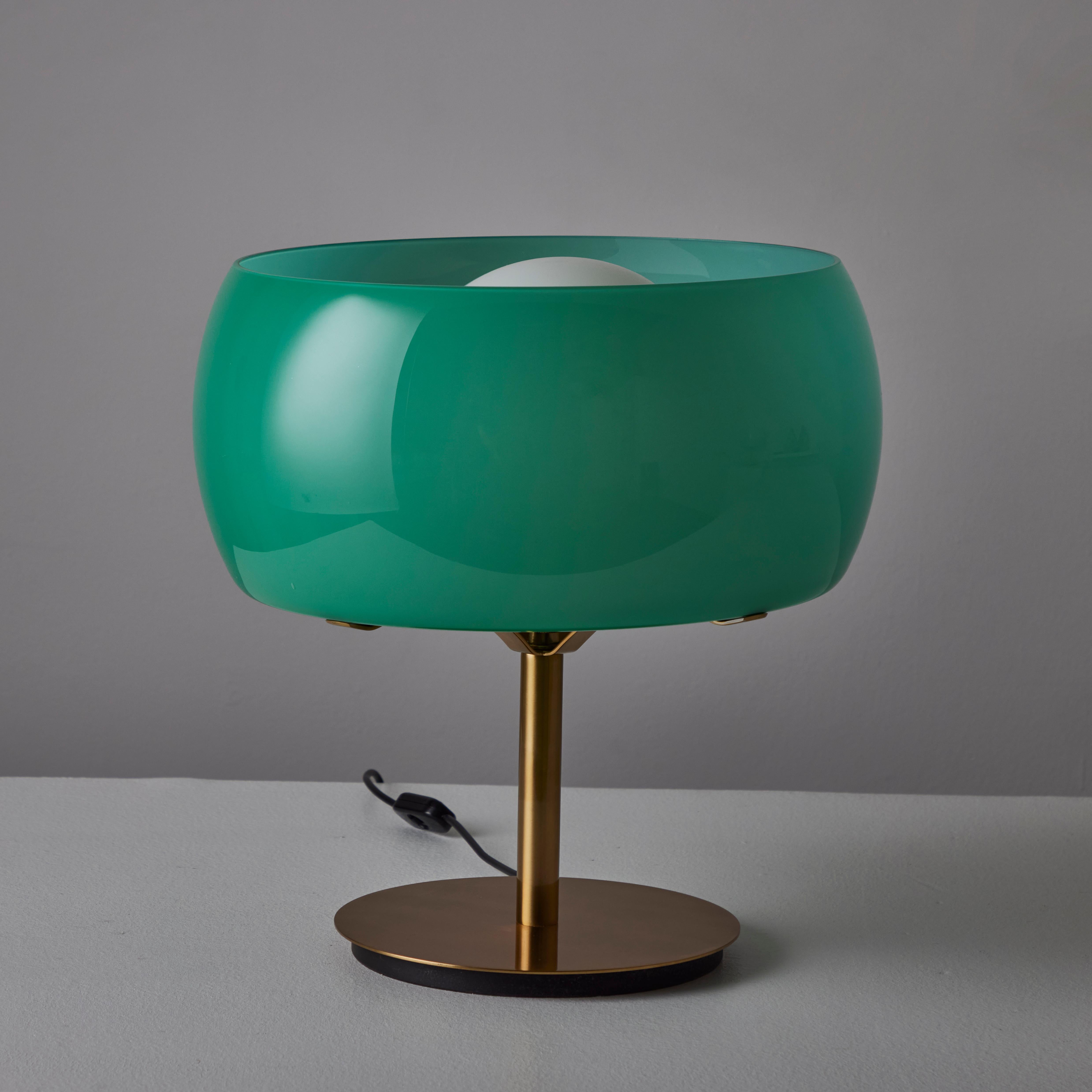 Rare pair of 'Erse' Table Lamp by Vico Magistretti for Artemide. Designed and manufactured in Italy, 1964. The base and stem of the lamp is constructed of polished brass. External orbital shade is made of teal colored glass which wraps around a