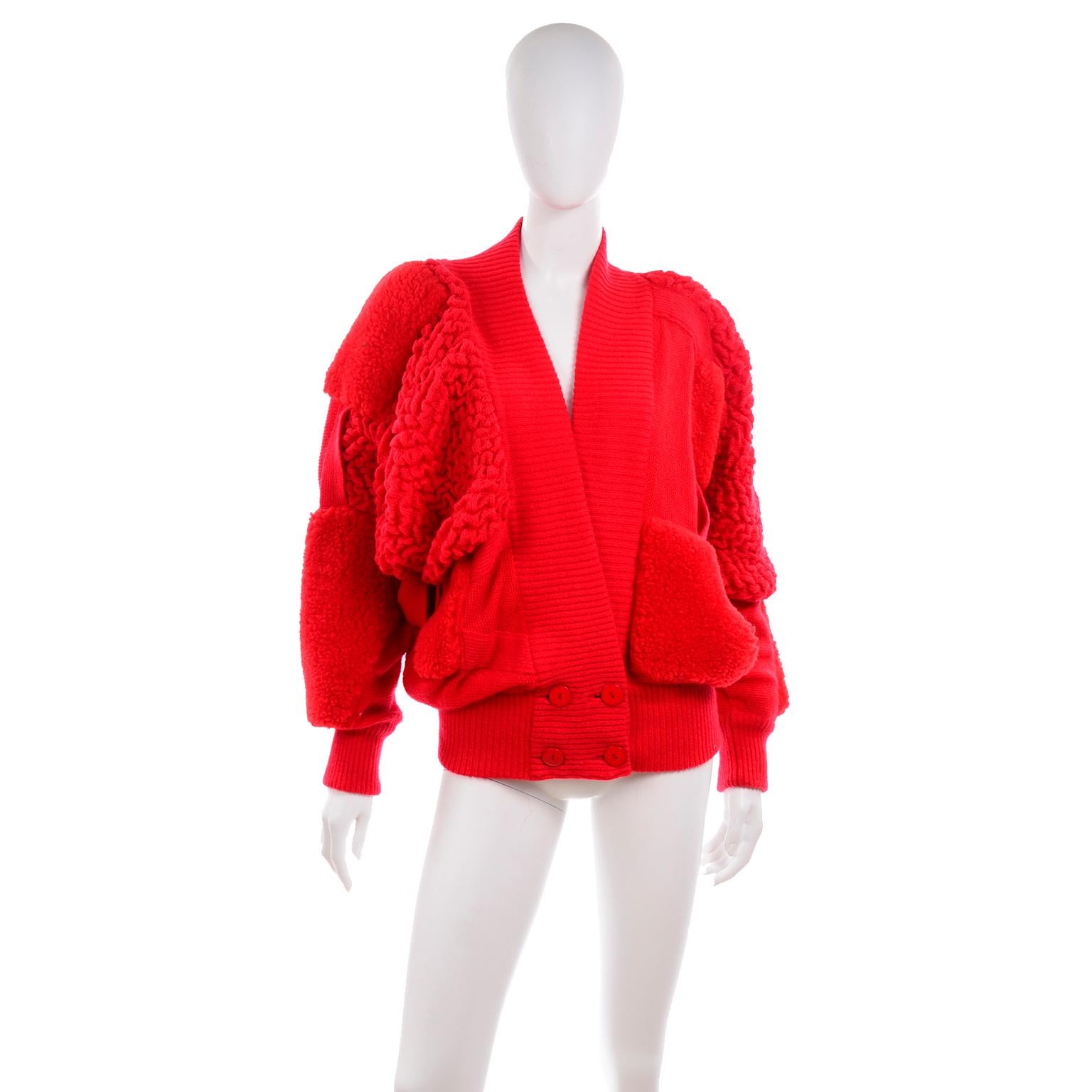 This incredible vintage red avant garde sweater was designed for Escada in the early 1980's.  This very unique double breasted sweater is patched with different materials and yarns and buttons near the hips. We love the dramatic dolman style sleeves