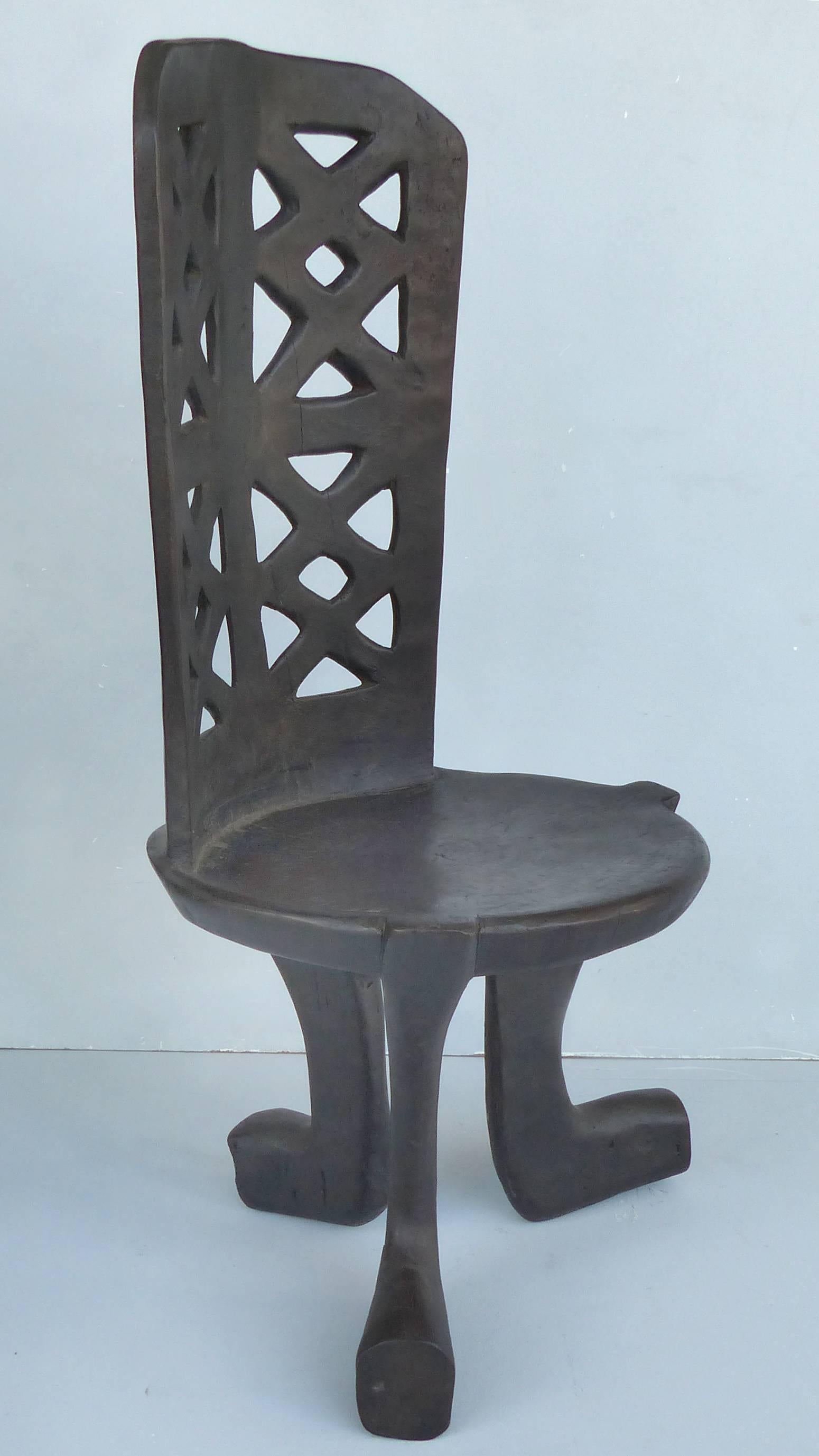 Rare Ethiopian Three-Legged Coptic Chair with Carved Crosses in Back Slat

Rare and unusual African three-legged chair from Ethiopia. This chair is carved from one piece of wood and has a back slat with carved crosses. Measures: Seat 15.75