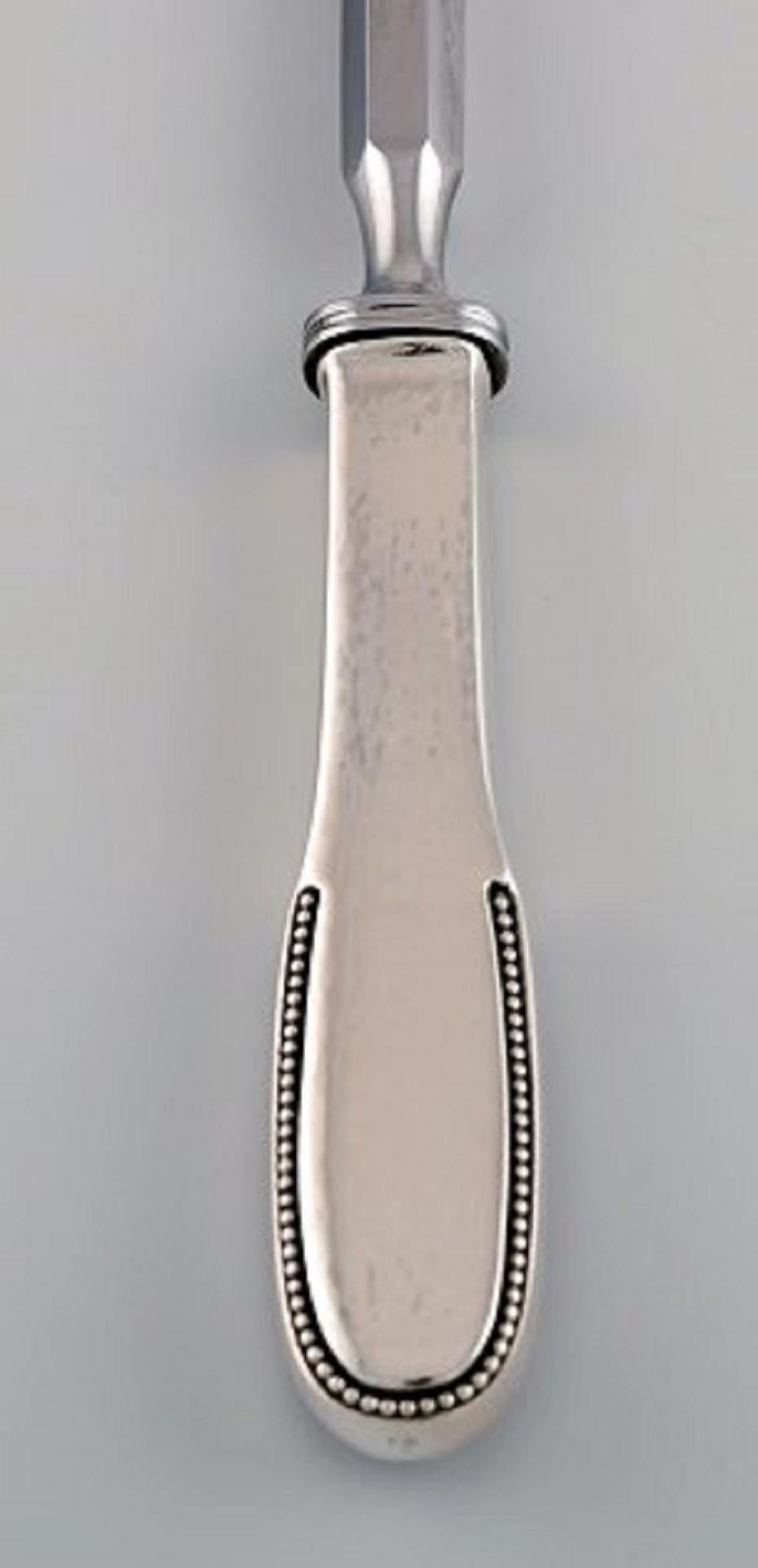 Rare Evald Nielsen number 14 sharpening steel in hammered silver and stainless steel. 1920s.
Length: 30.8 cm.
Stamped.
In excellent condition.
Our skilled Georg Jensen silversmith / jeweler can polish all silver and gold so that it appears as