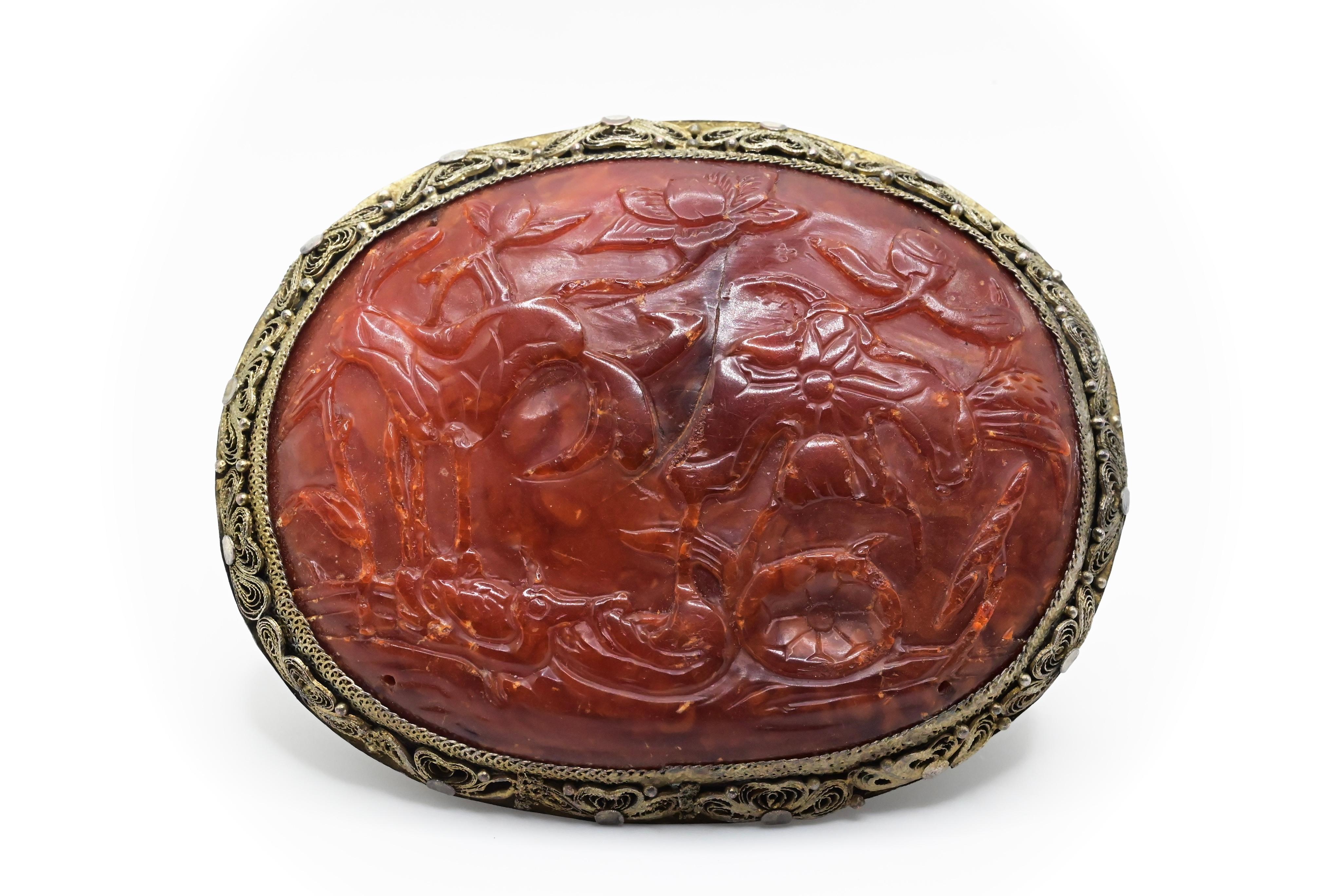 This is a stunning antique Chinese carved amber brooch. The age of the amber is approximately 150-200 years old. Amber of this quality and dark hue tends to be around of that age. Amber slowly adapts from bright yellow to dark red and purple as it