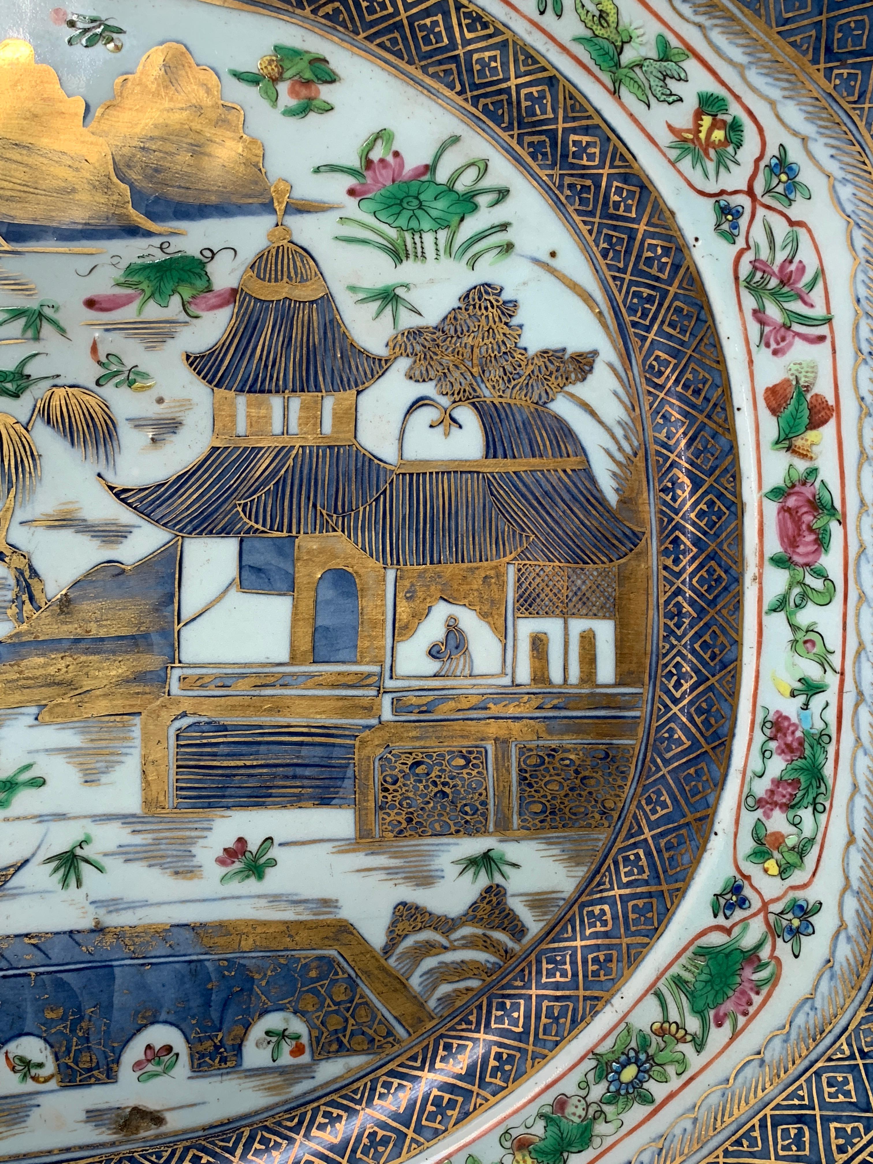 A stunning very large platter with underglaze blue and then with additional famille rose or rose medallion frieze added over the glaze and then further embellished with minutely painted highlighting in gold.