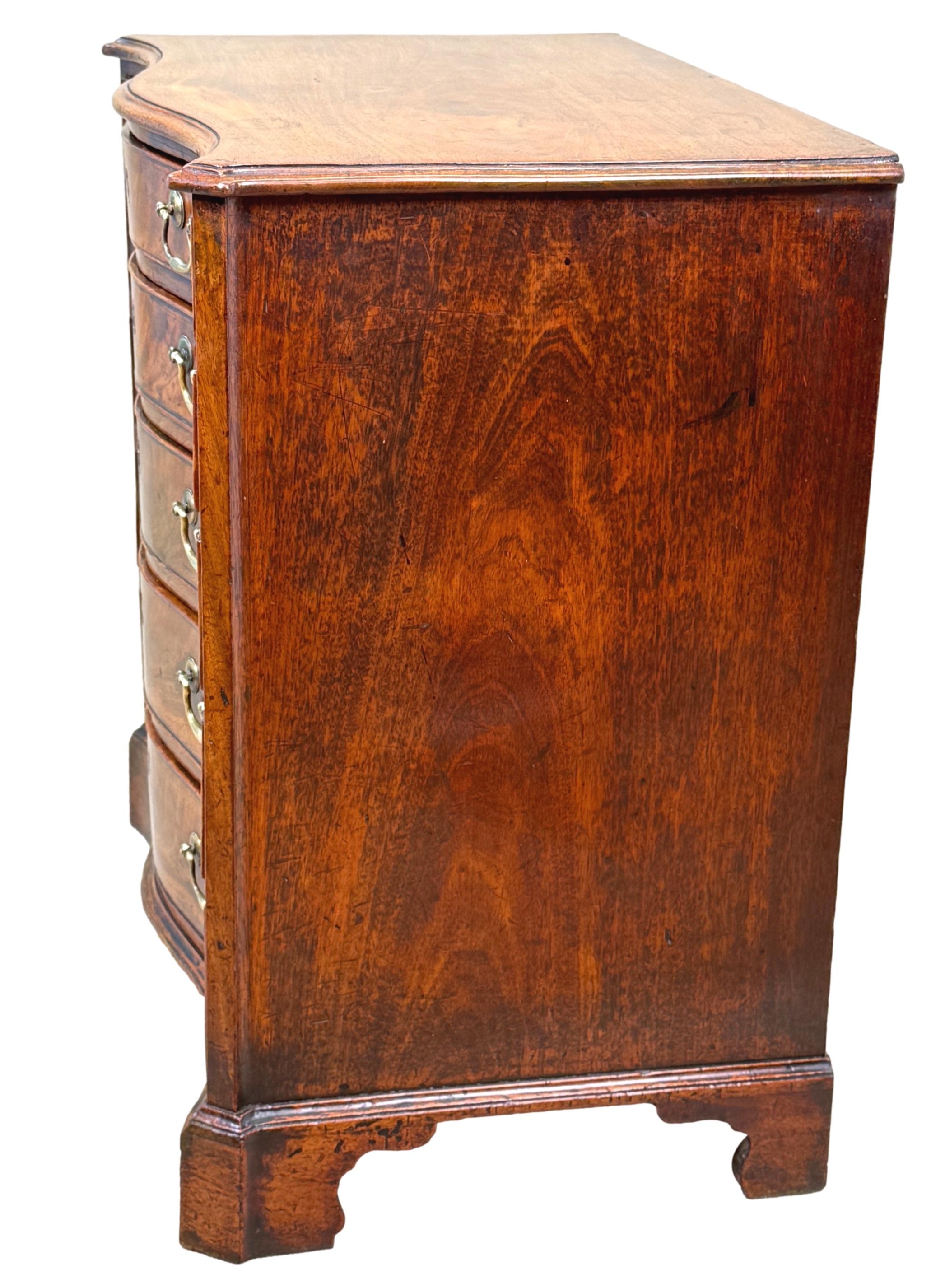 Superbe commode serpentine en acajou du XVIIIe siècle de la période Chippendale, exceptionnellement rare et de très petite taille, avec un plateau de forme bien figurée et un bord mouluré, sur une façade de forme audacieuse avec cinq tiroirs bien