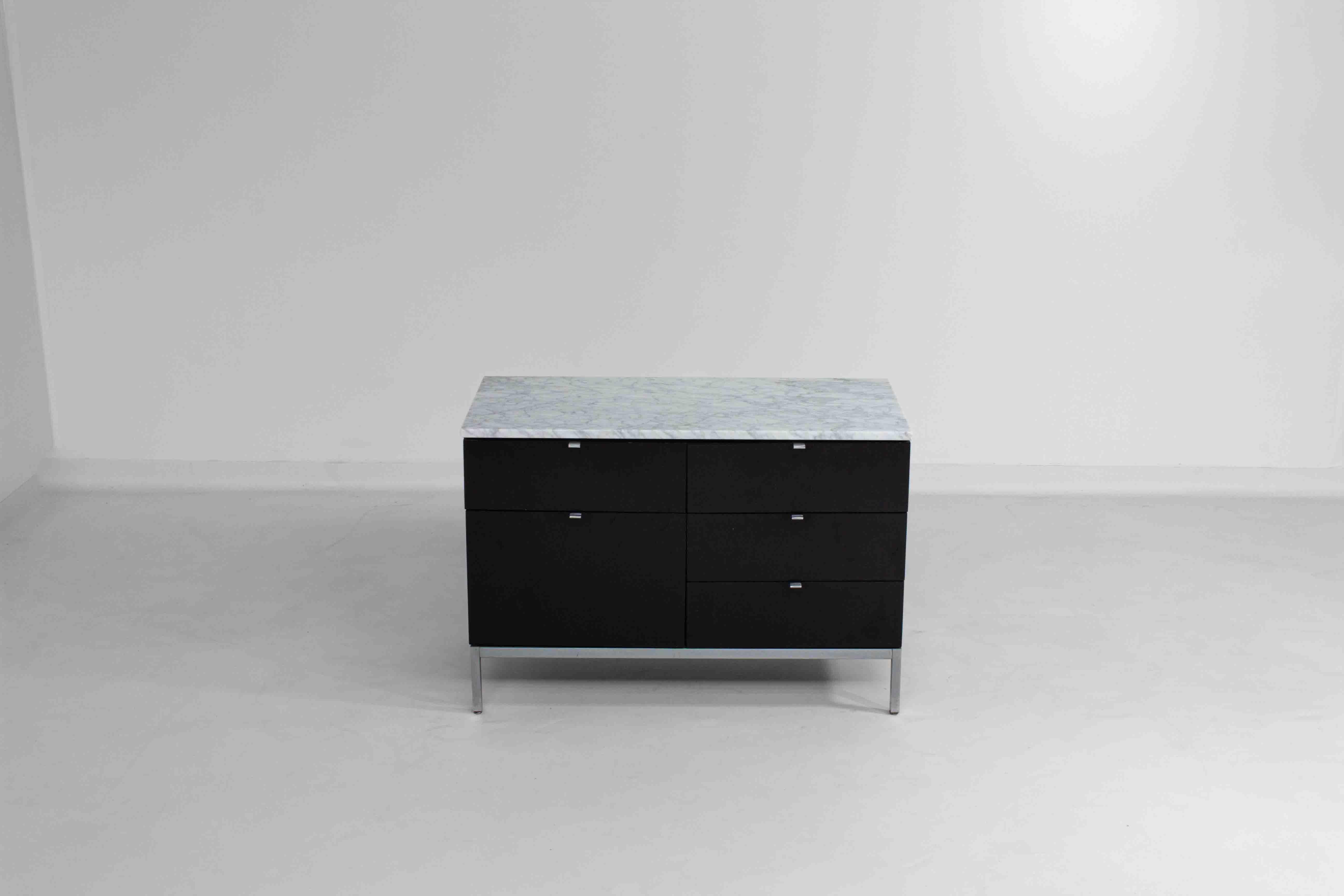 This small vintage credenza was designed by Florence Knoll in the 1960s for Knoll International. It features a sleek design with black ebonized wood and a Carrara marble top, exemplifying Knoll’s minimalist aesthetic and high-quality craftsmanship.