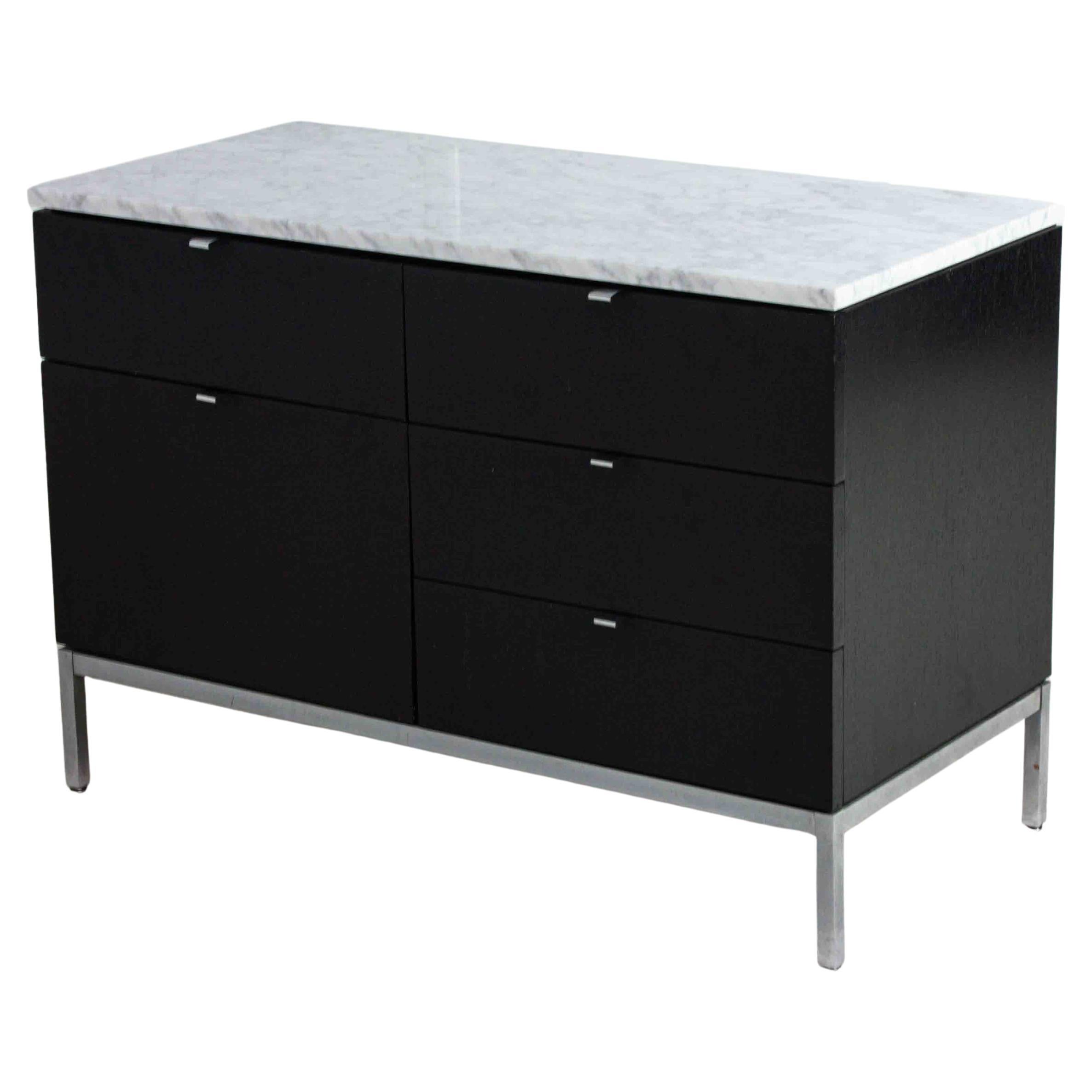 This small vintage credenza was designed by Florence Knoll in the 1960s for Knoll International. It features a sleek design with black ebonized wood and a Carrara marble top, exemplifying Knoll’s minimalist aesthetic and high-quality craftsmanship.