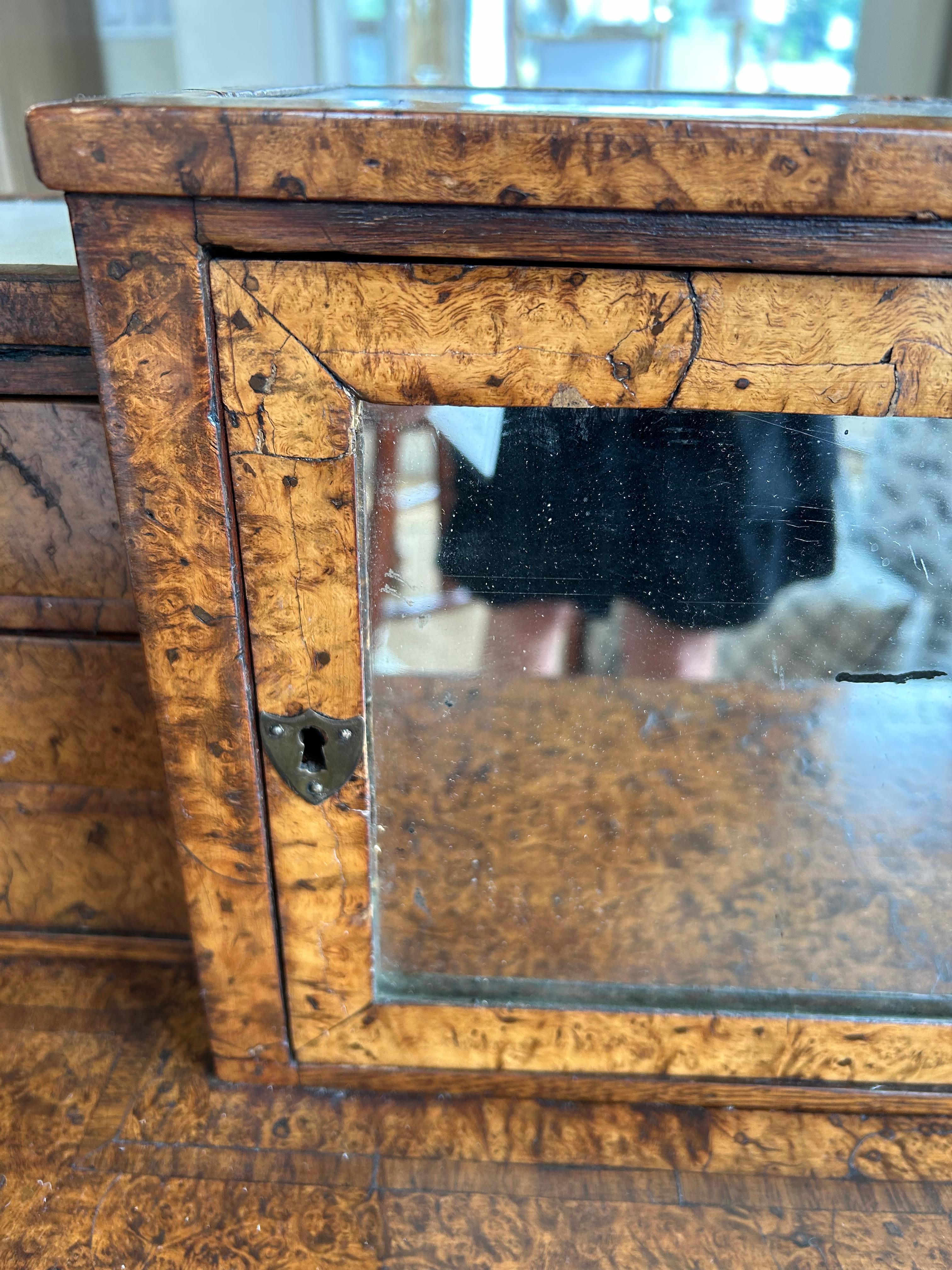 Exquisiter und seltener vielseitiger Schreibtisch oder Frisiertisch aus lebhaft gemasertem Ahorn mit weißem Marmor als Intarsie auf der Oberseite, verspiegelte kleine Fronttür mit Ablage und winzige Schubladen auf jeder Seite der Tür.  Die einzelne