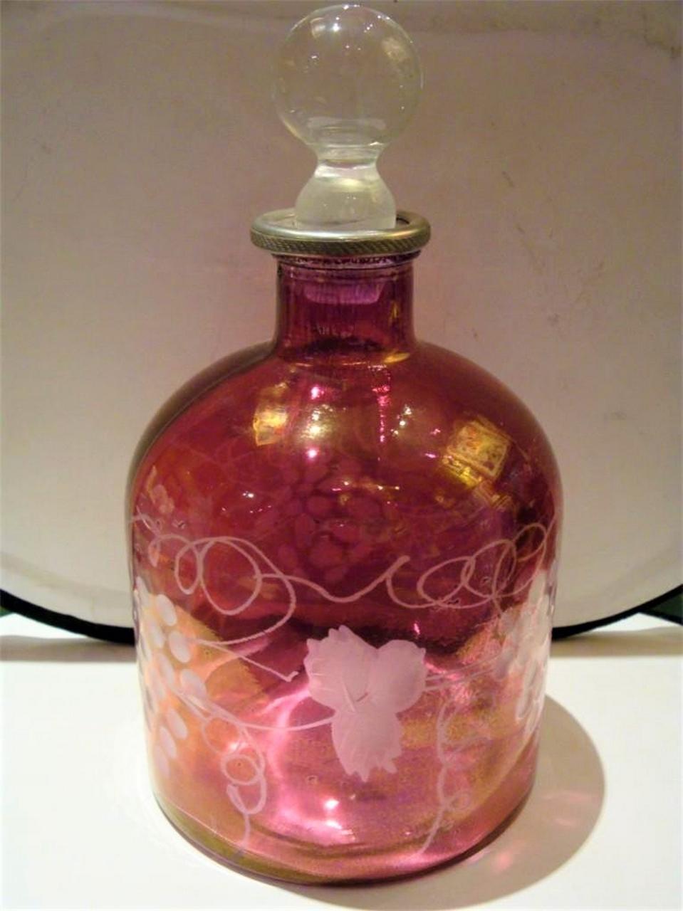 The Following Item we are offering is a Rare French Cranberry Etched Glass Decanter Bottle. Bottle is Etched with Clusters of Grapes on Vines and Beautifully Adorned with a Fine Glass Ball Top. Beautifully done with Exquisite Detail. Original Price
