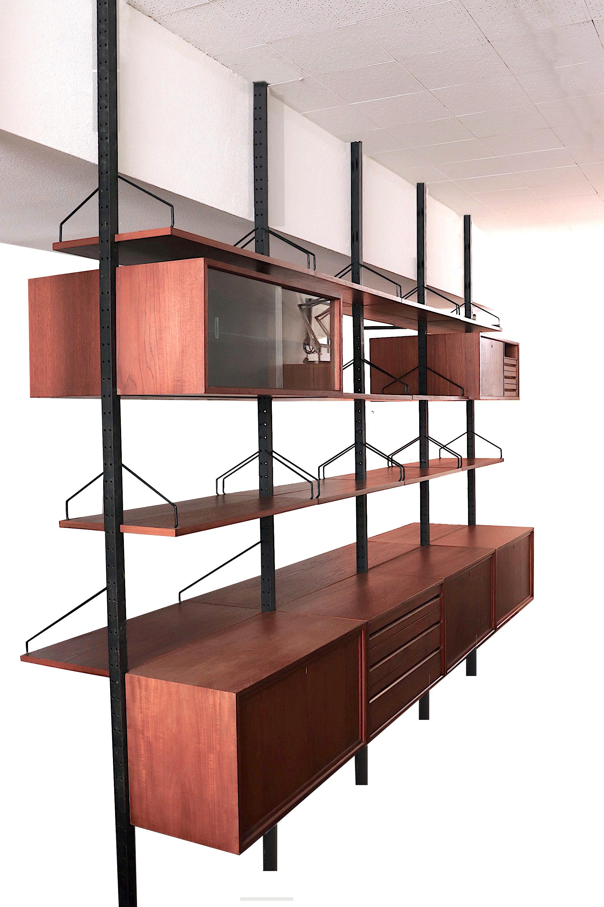 Extra large double sided teak room divider with metal tension supports. Very impressive two sided - four section unit with ample storage and shelving. Outfitted with teak cabinets with both glass and teak sliding doors, drop-down cabinet and endless
