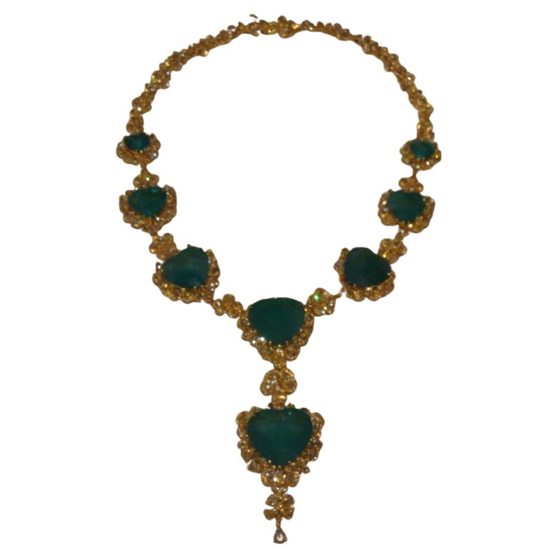 Il seguente articolo è una rara e importante collana di proprietà in oro giallo 18KT con 8 magnifici smeraldi a forma di cuore affiancati da raffinati diamanti gialli taglio rosa senza difetti e con motivi floreali. Un pezzo eccezionale di