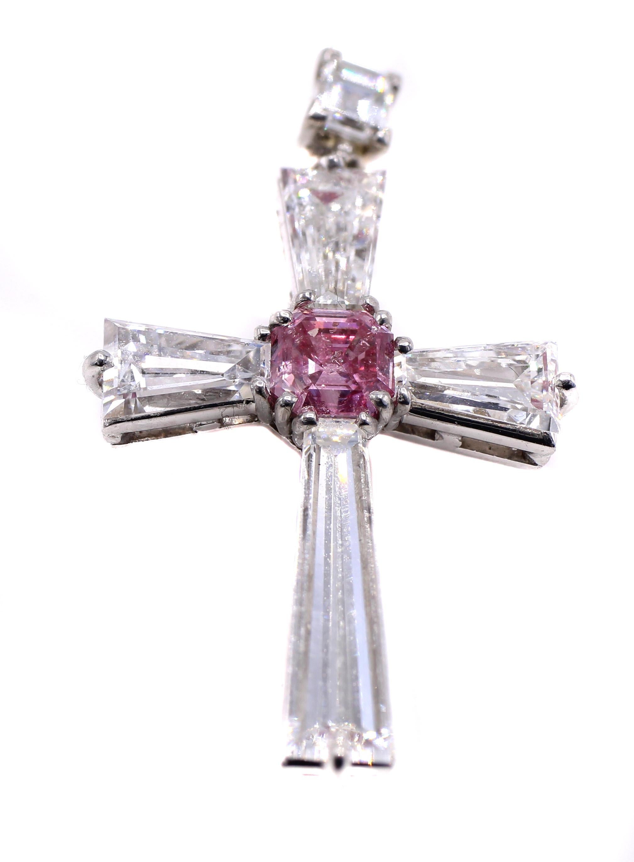Ce pendentif croix en platine, rare et unique, présente un diamant de taille radiant de couleur Nature Fancy Intense Purplish Pink pesant 0,55 carats, accompagné d'un rapport du GIA. Elle est ornée de trois très grandes baguettes blanches effilées,