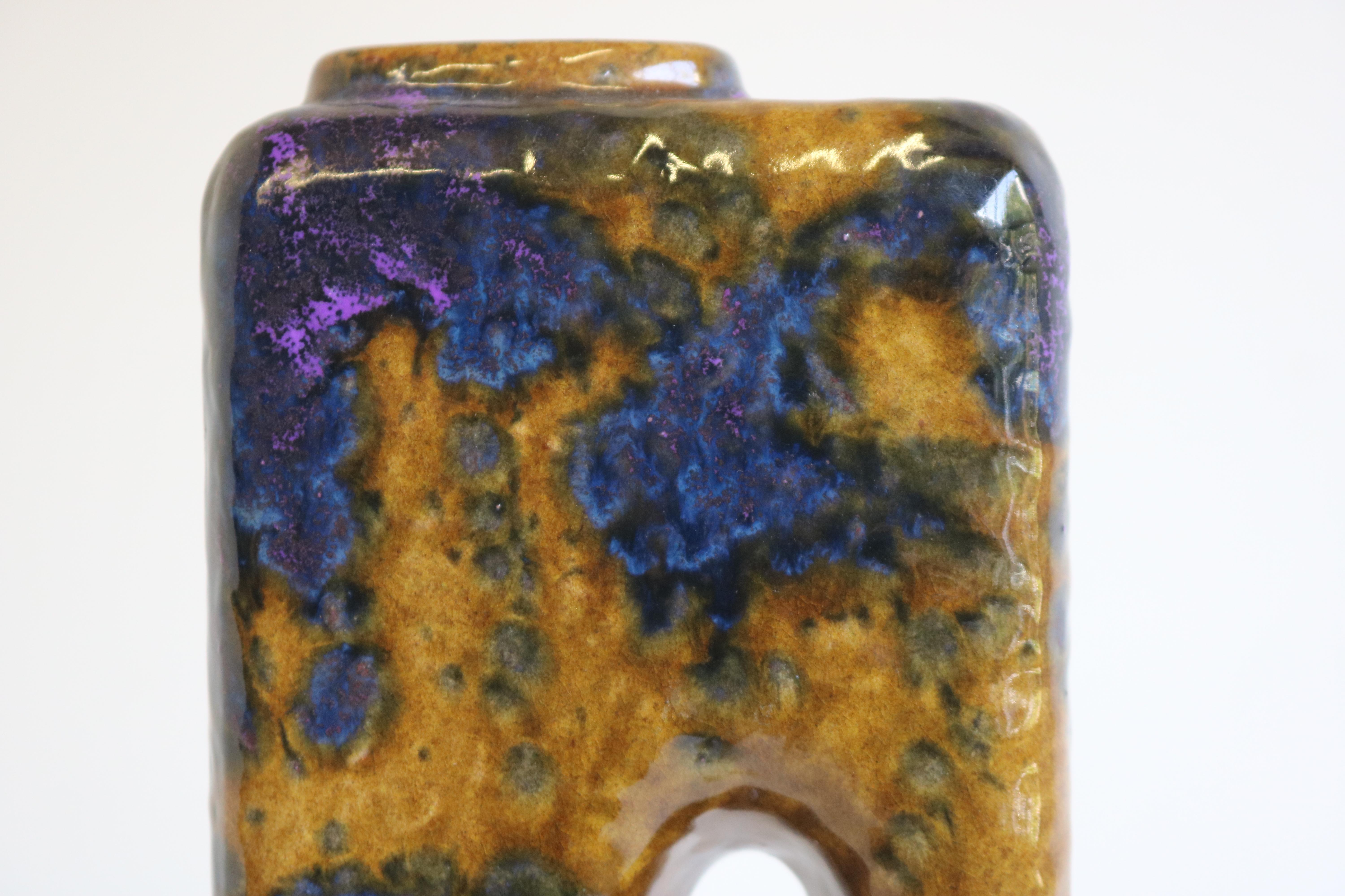 Sie suchen nach einem schönen Stück im Vintage-Stil, das Ihre Einrichtung bereichern soll? Diese faszinierende Kaminvase mit blauen, violetten und beigen Farben im Stil von Fat Lava von Marei Keramik ist ein echter Hingucker. Die 1970 in Deutschland