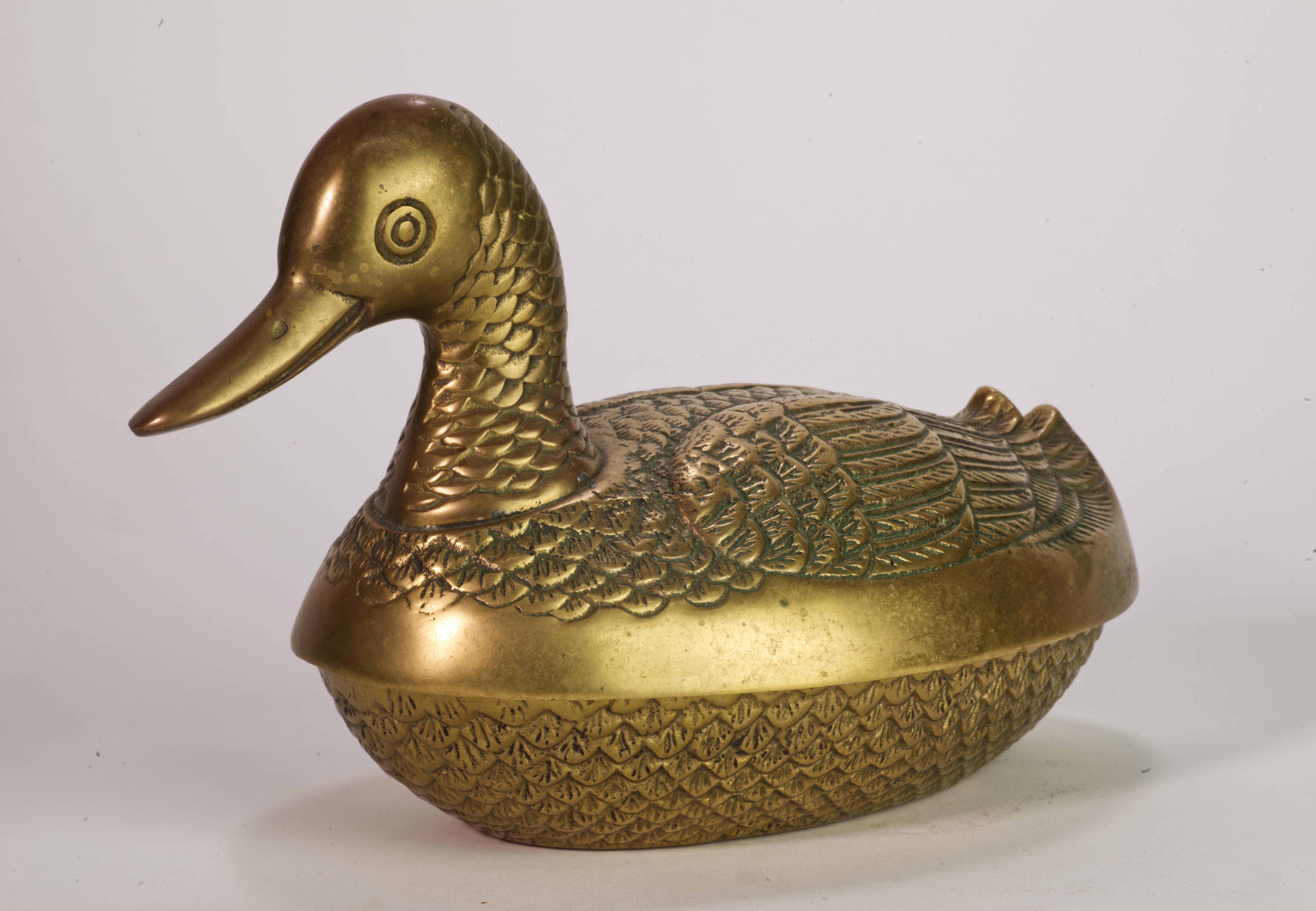  El cuenco de bronce moderno de mediados de siglo con tapa está diseñado en forma de pato estilizado, con la cabeza y el cuello que sirven de asa para la tapa. Tanto la superficie de la tapa como la del cuenco están finamente detalladas, con el