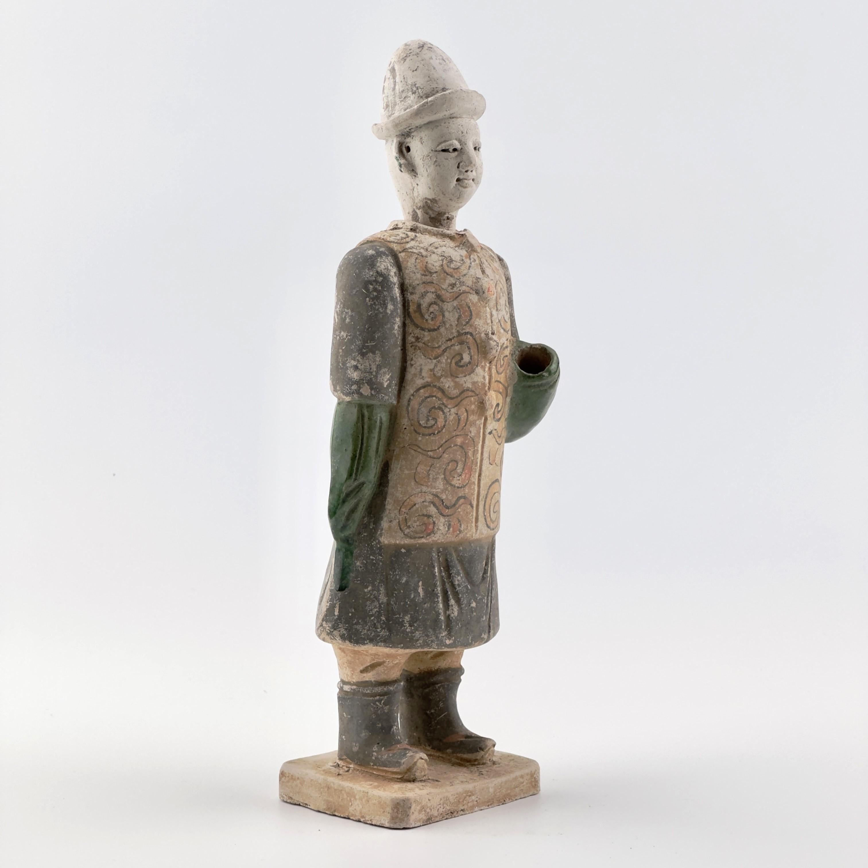 Statues of attendant crafted from terracotta, dressed in a black coat-like garment with a vest adorned with swirling patterns. Set on rectangular bases.

Period: Ming Dynasty 
Medium: Glazed Pottery
Type: Figure
Size :  12cm(Diameter) x