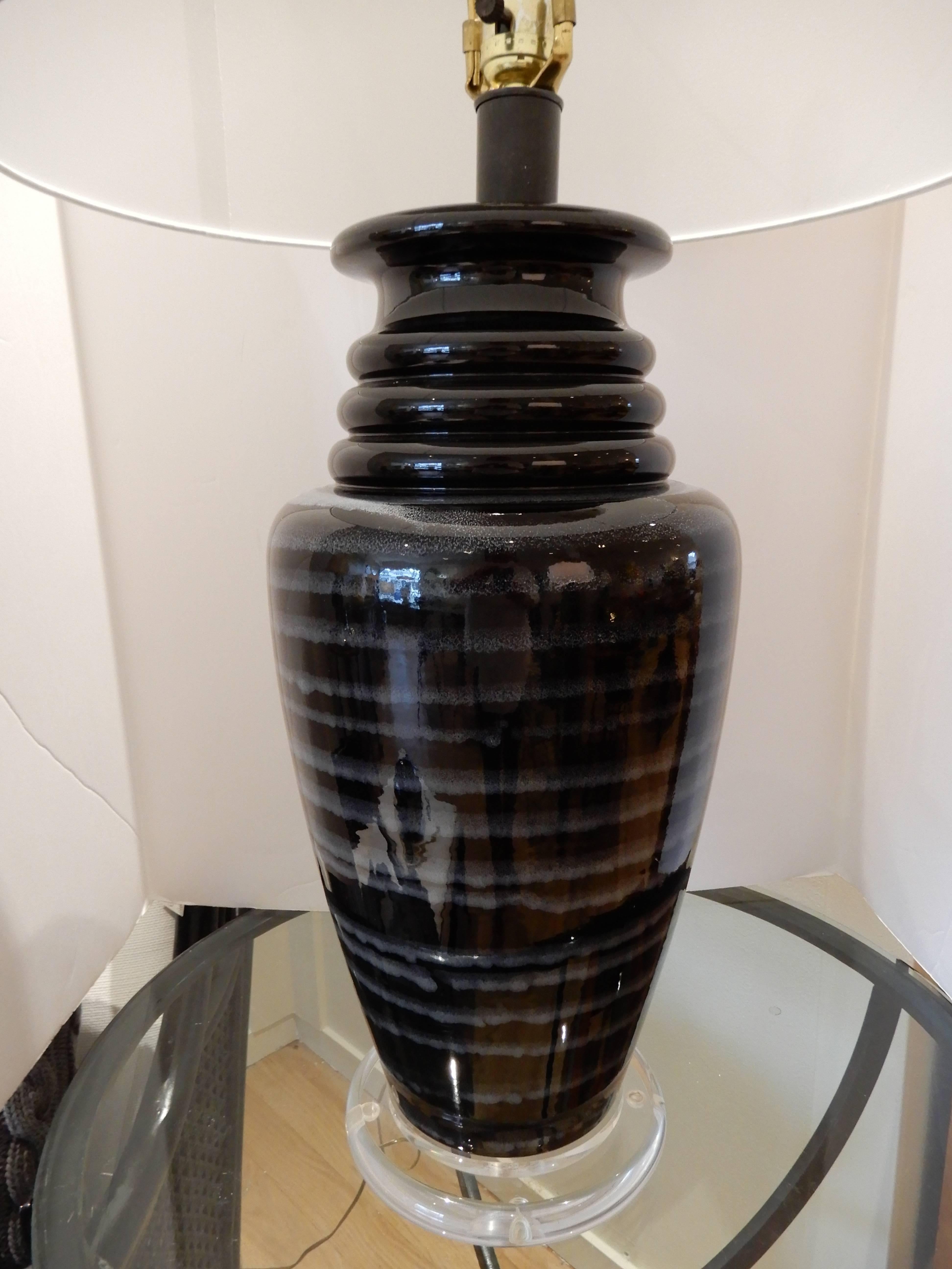 A  1970s tall black and white  Art Glass table lamp. Hand blown, with a  Lucite base. Three way switch, original black finial.
White drum shade, works in many settings.