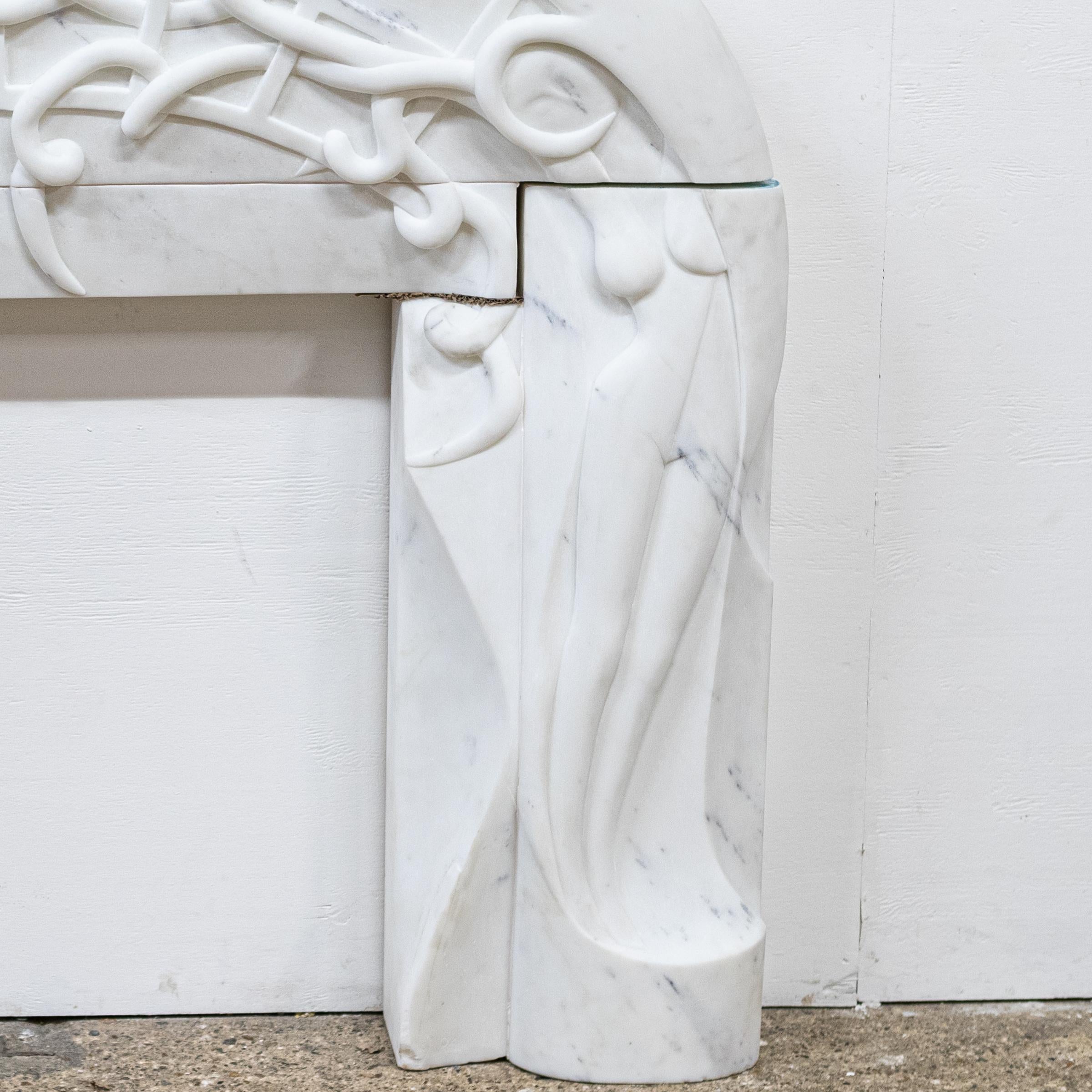 An impressive and monumental piece, this large reclaimed contemporary fire surround is a rare find.

The arched form is adorned with organic and finely carved feminine depictions.

Comprised of 3 substantial and solid blocks of statuary marble, the