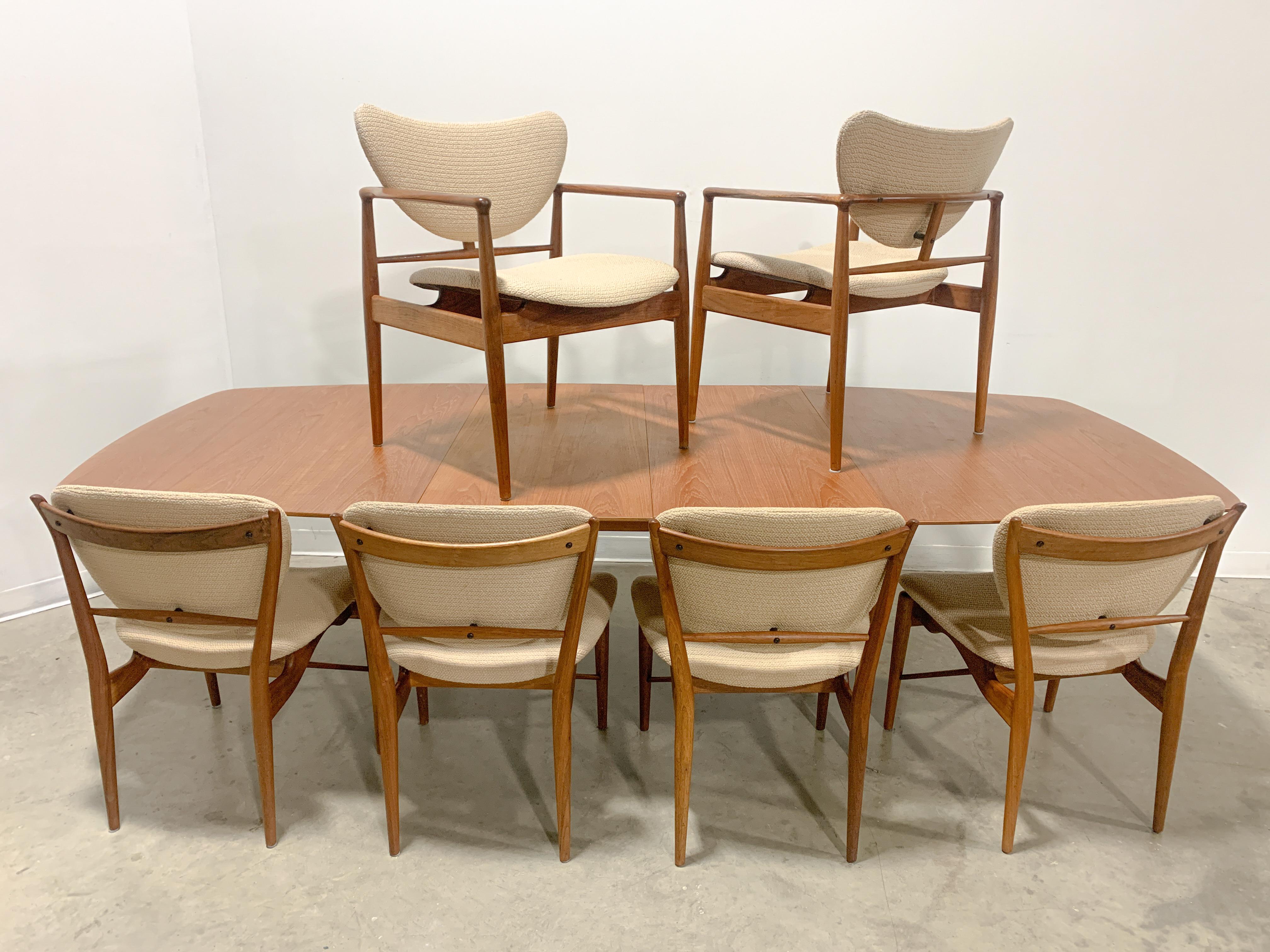 Superb dining table and chairs designed by Danish legend Finn Juhl and hand made by Baker furniture circa 1952. Teak veneer top over solid maple extendable dining table with two leafs on a walnut base with sublime edge details. Main table top is in