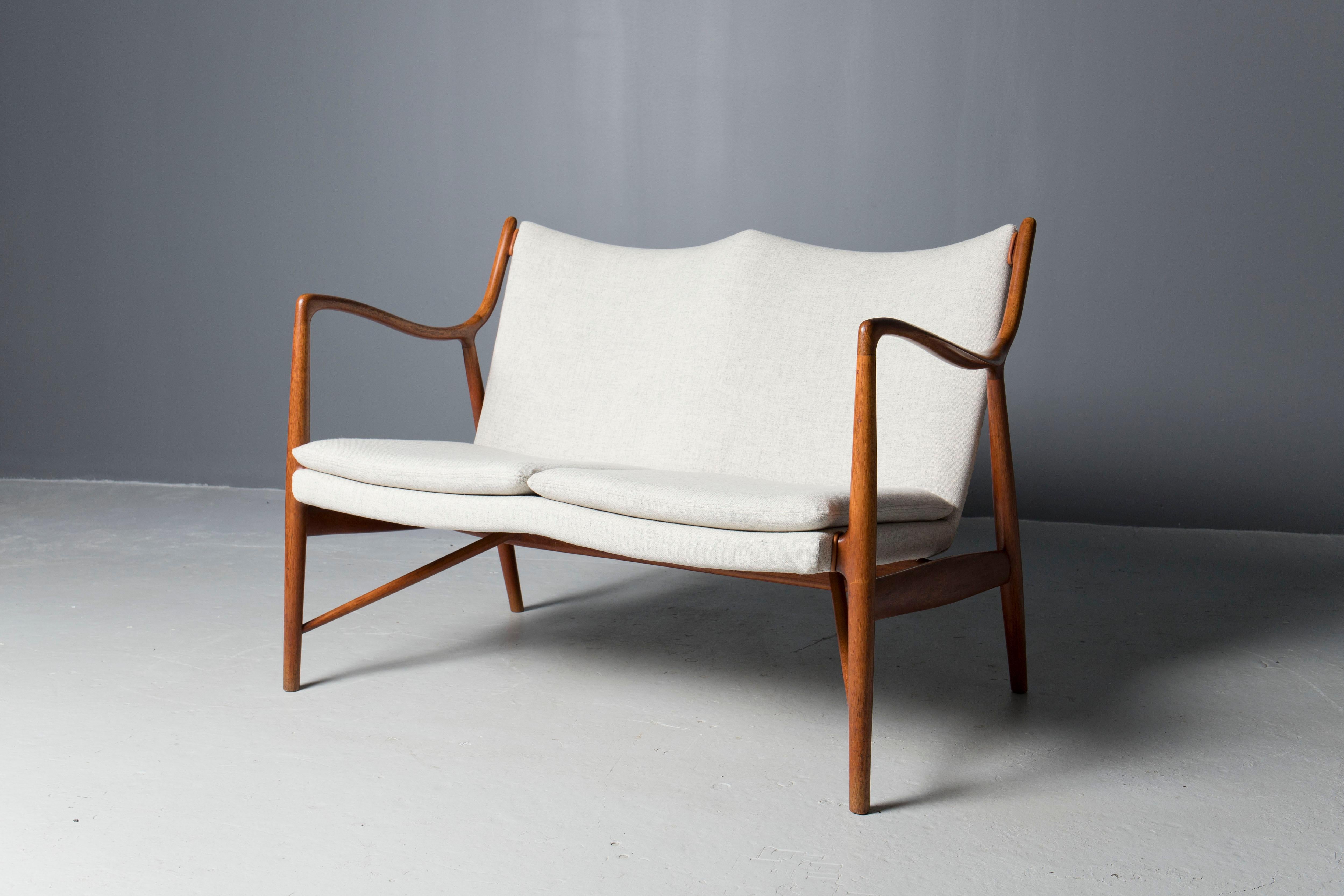 Rare et ancien modèle de canapé 45, conçu par l'architecte danois Finn Juhl et exécuté par Niels Vodder au début des années 1950.
Le cadre sculptural en teck a été nettoyé et huilé par des professionnels, la tapisserie a été mise à jour avec de la