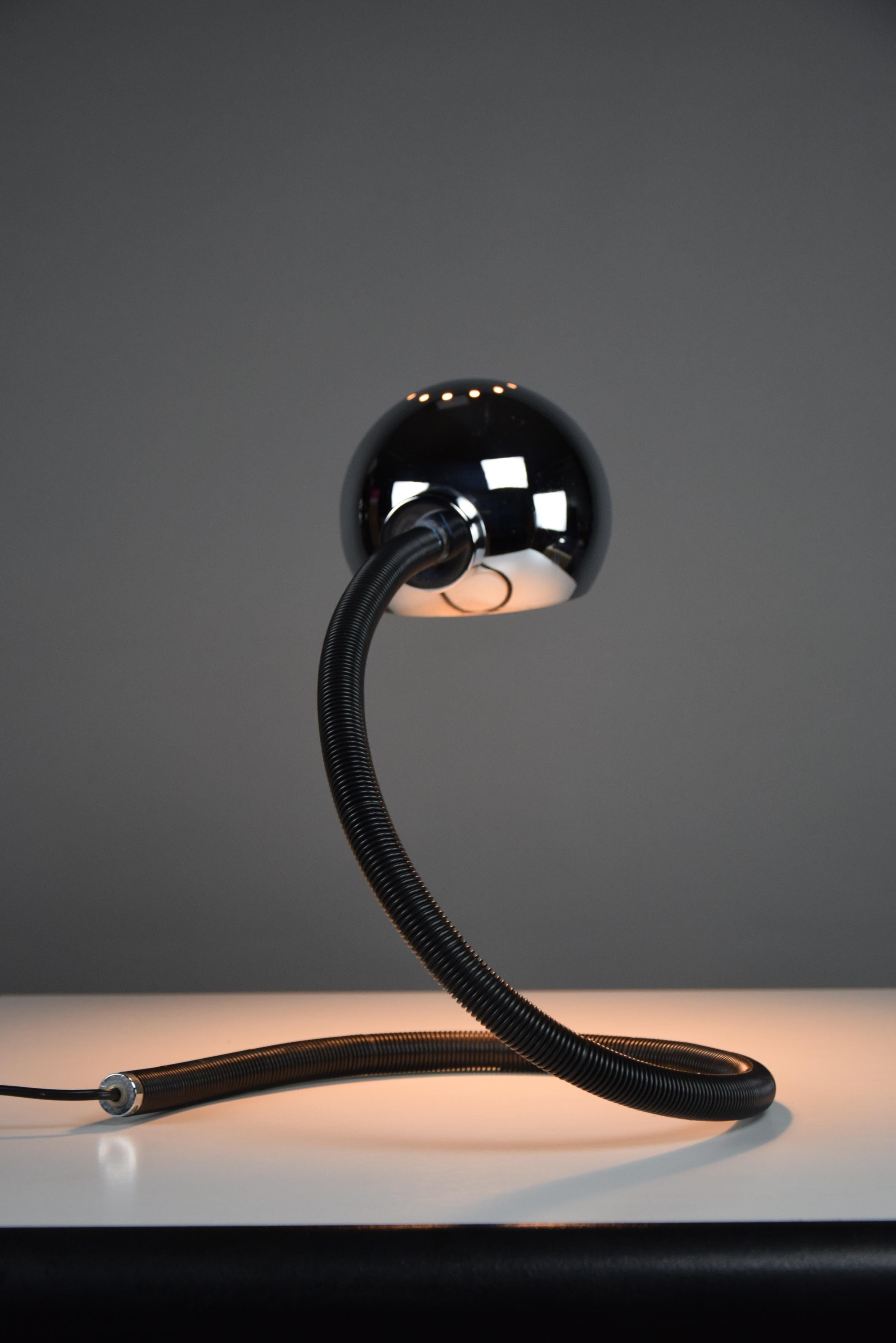 Introducing the timeless elegance of the Hebi table lamp, a masterpiece of design by Isao Hosoe for Valenti Luce in the 1970s. With its iconic large black adjustable and flexible frame, the Hebi lamp effortlessly blends form and function. Illuminate