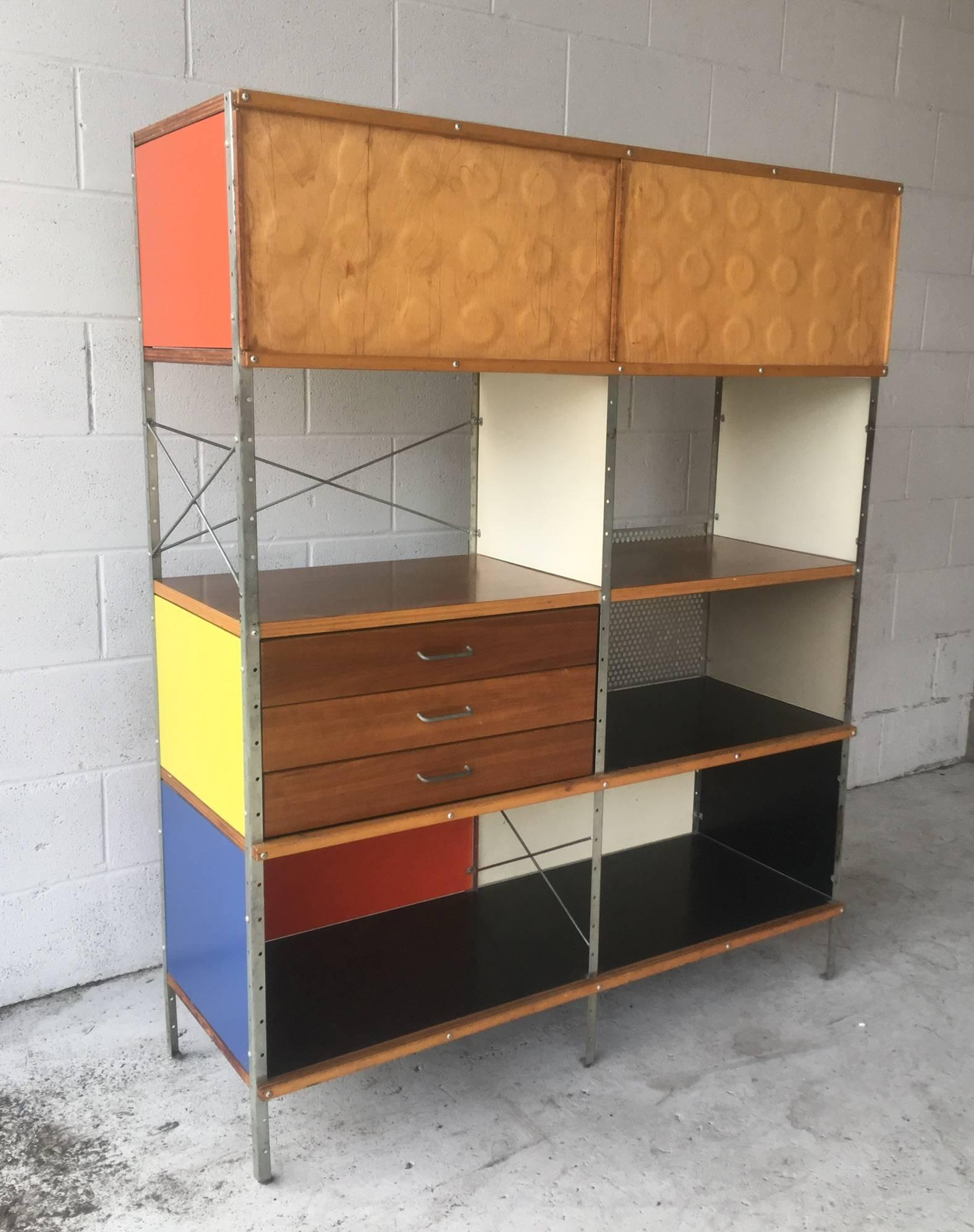 The holy grail for Eames collectors. This marvellous ESU is from the first generation. Features walnut veneer and primarily colored panels, the most sought after combination. Also features two birch dimple doors for top section. Drawers function