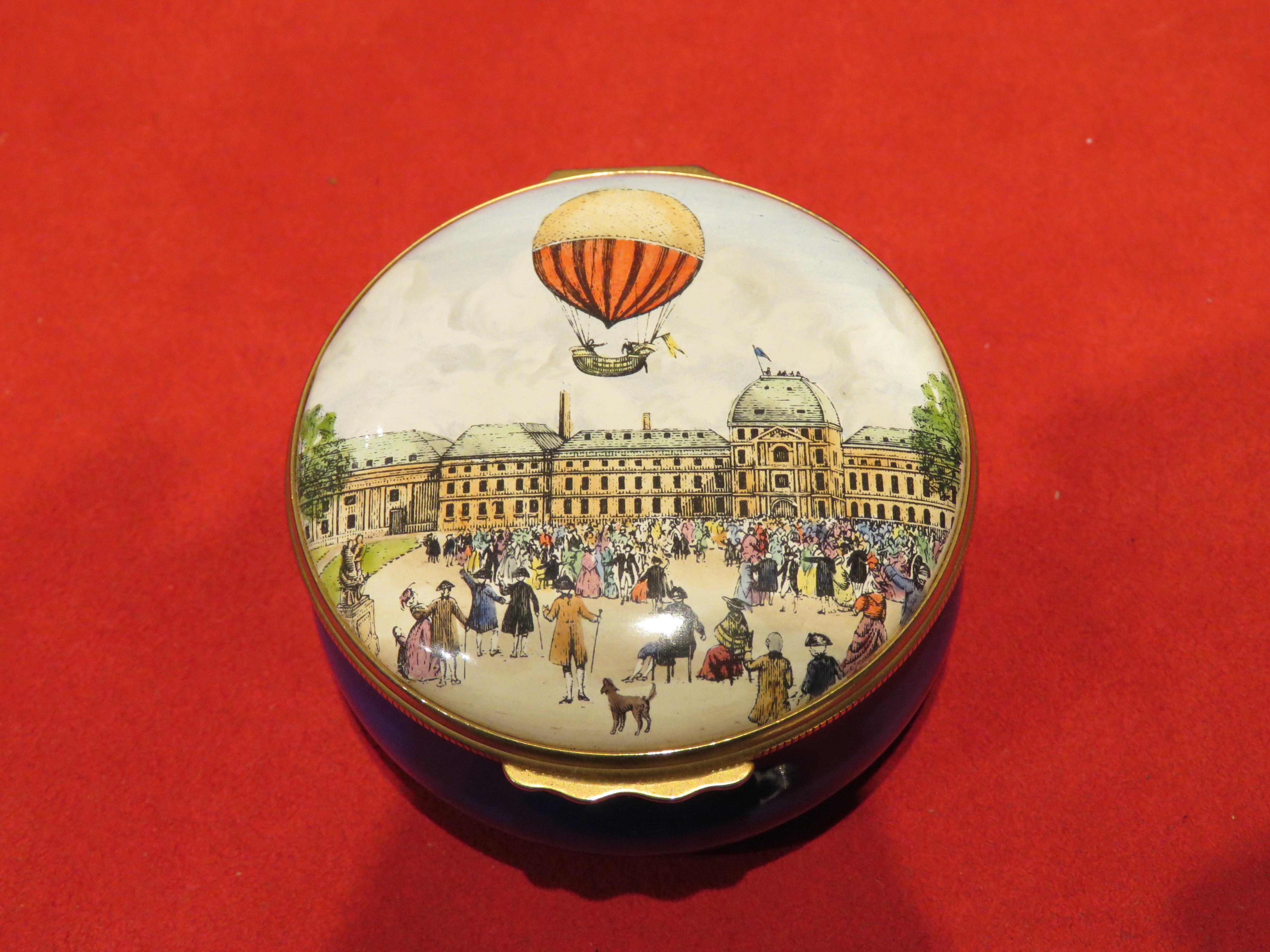 The Following Item that we are offering is A Beautiful and Unusual RARE COLLECTORS HALCYON DAYS England Porcelain Box, featuring Professor Jacques Charles and Mr. Robert ascent in a Hot Air Balloon in 1783 over Paris. Outstandingly done with