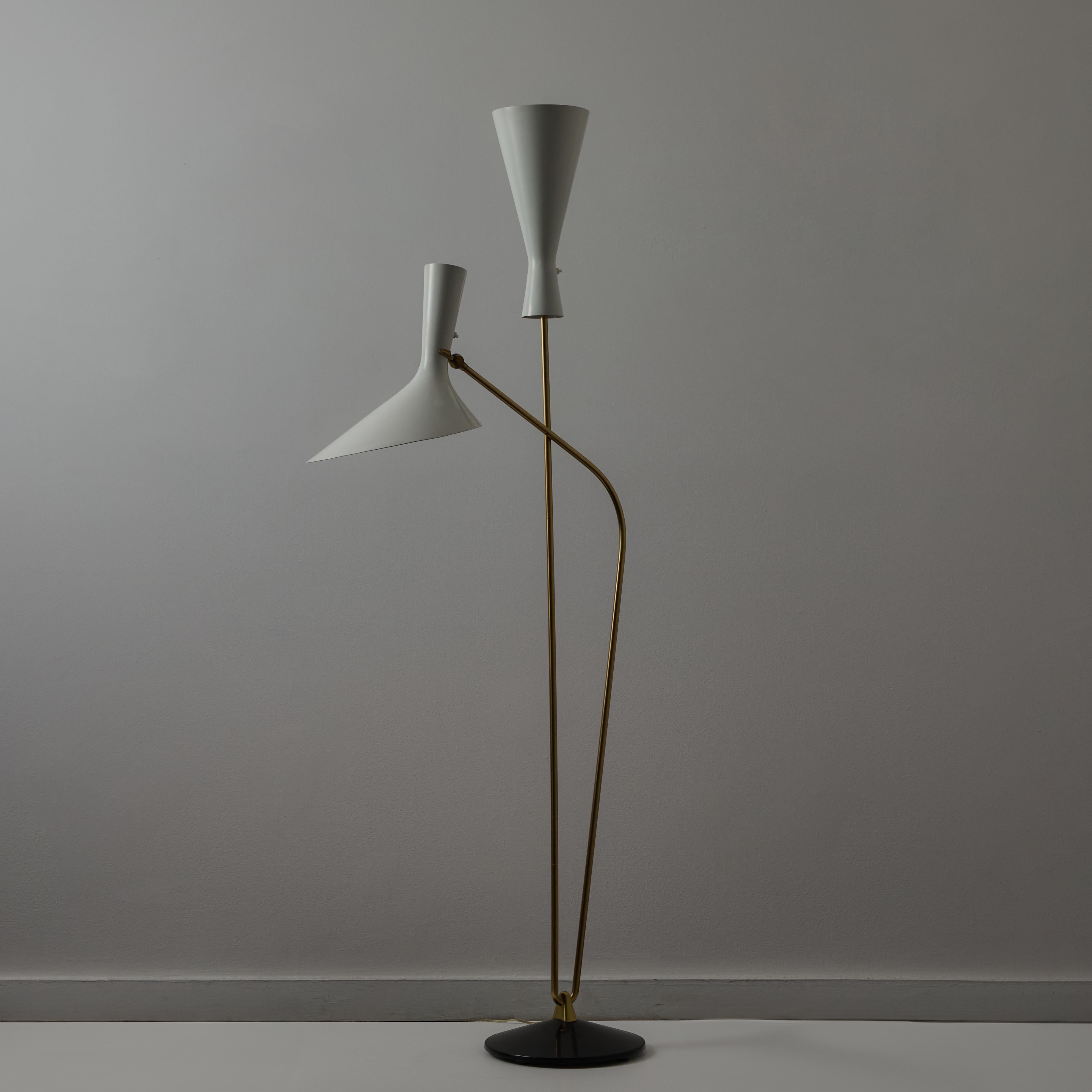 Rare Floor Lamp by Carl Moor for BAG Turgi. Designed and manufactured in Switzerland, circa the 1960s. Two white enameled shades cascade up through a double brass stem armature. One shade is an up-light and the other is a down-light. Each light can