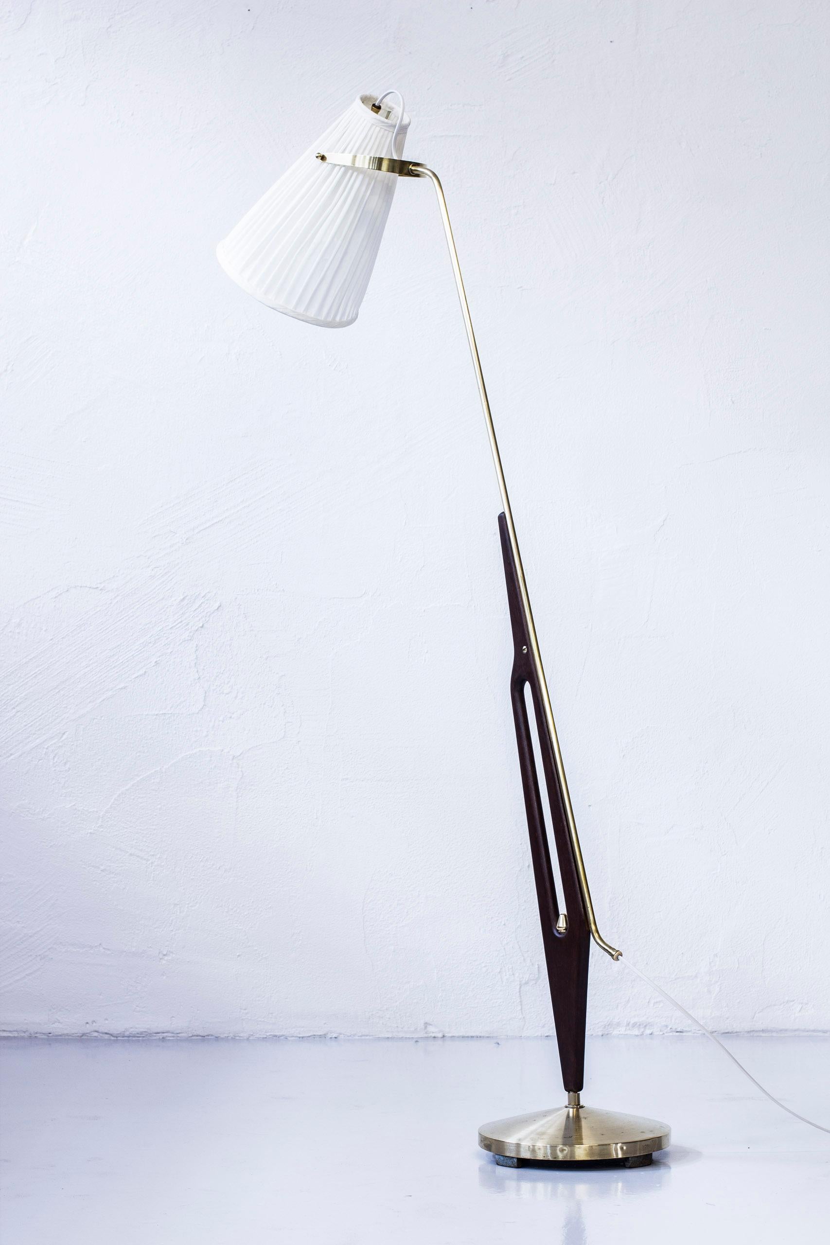 Rare floor lamp designed by Hans Bergström. Produced by ASEA in Sweden during the early 1950s. Made from brass, with a solid mahogany in the main part and hand sewn chintz fabric shade. Light switch on the chord. Very good condition with signs of