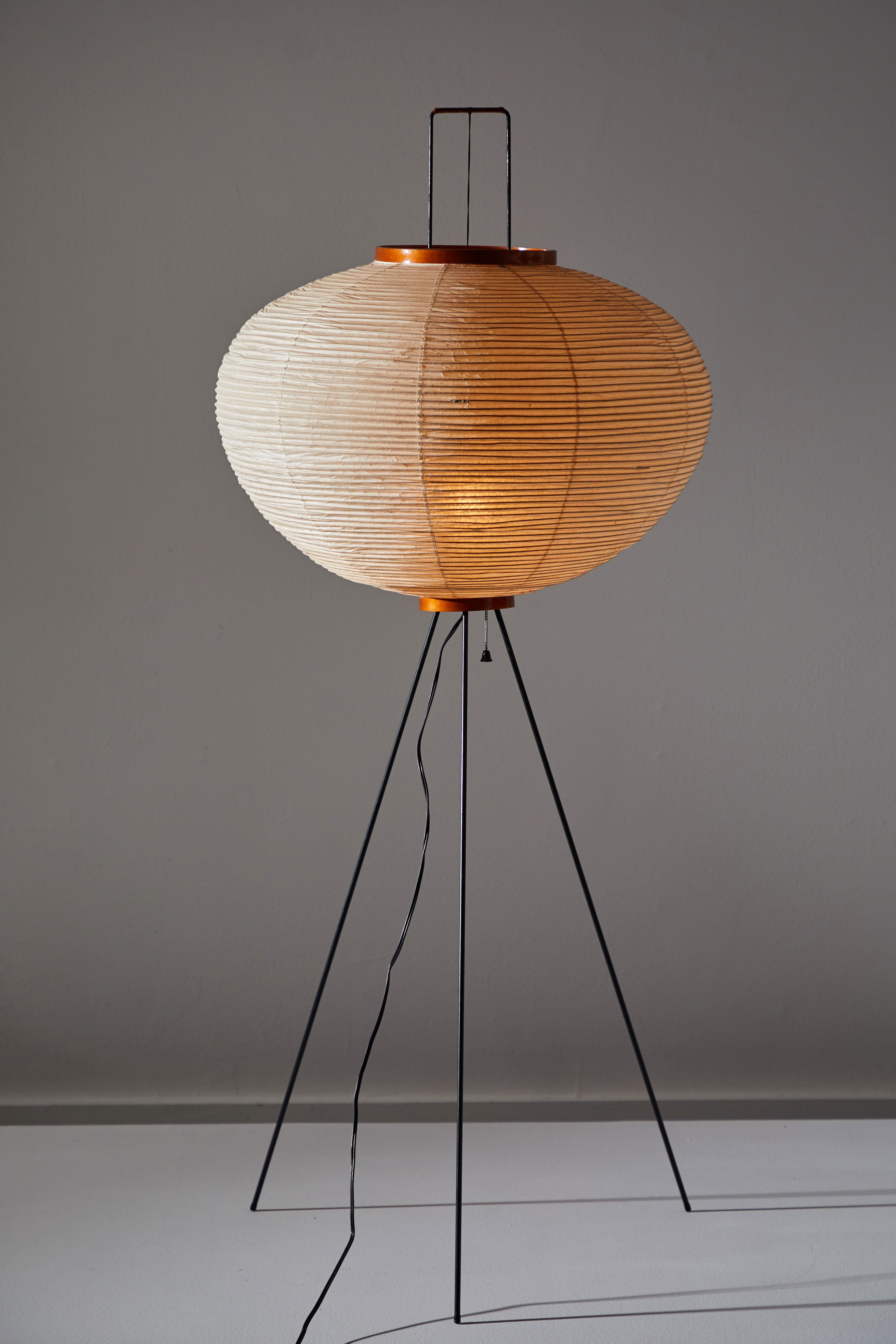Rare and early floor lamp by Isamu Noguchi. Manufactured for Akari in Japan, circa 1950s. Original Sun and Moon stamp. Rice paper, metal, wood. Original cord. Takes one E27 25-40w maximum bulb.