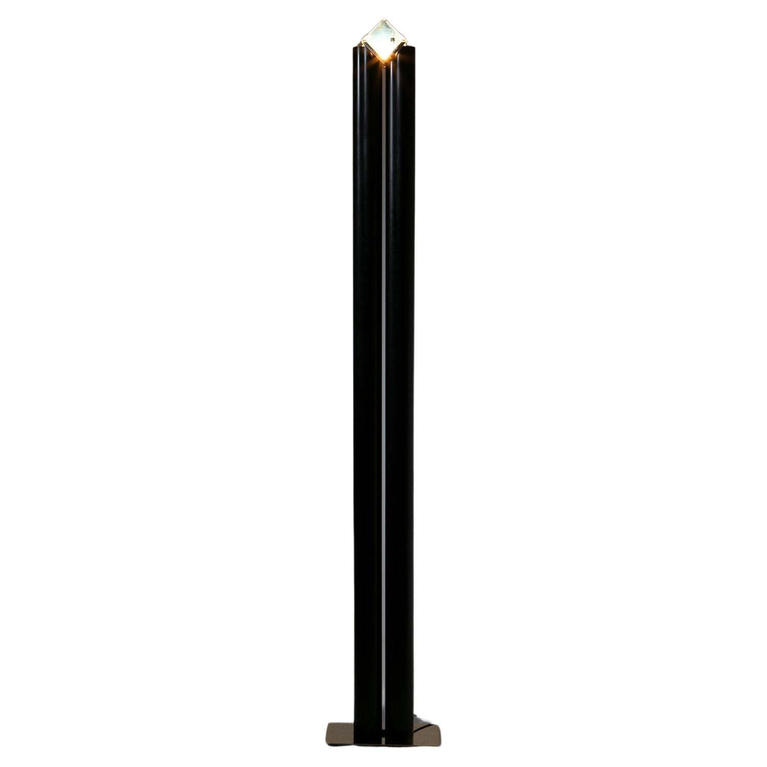 Metal floor lamp by iTre Murano.
Gold floor plate supporting two metal tubes with a bright glass top.
Silent totemic presence for domestic interiors.