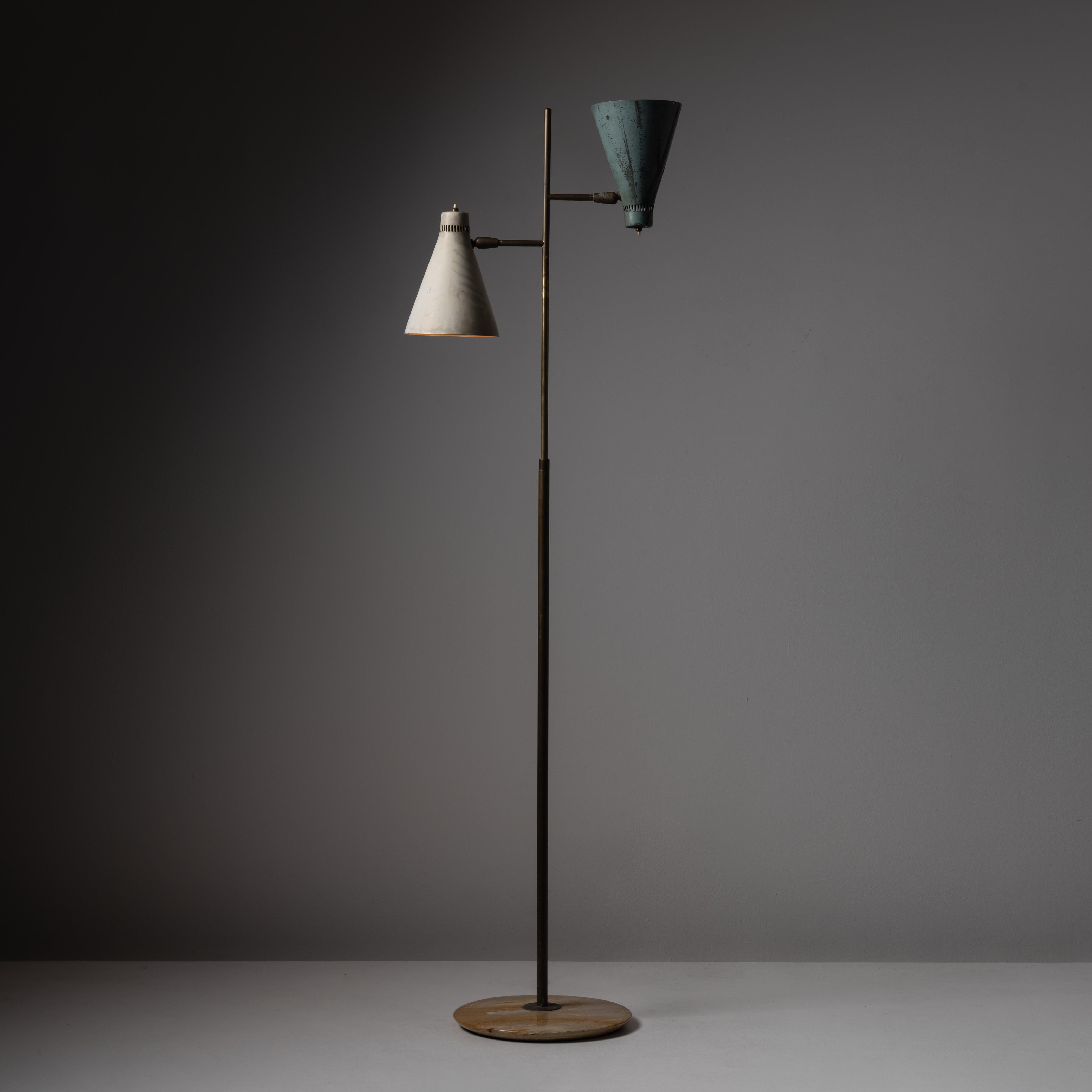 Rare floor lamp Giuseppe Ostuni for Oluce. Designed and manufactured in Italy, circa the 1950s. A dual head floor lamp, with a bone and verde combination of shades, along with a beautiful marble base. Stem hardware is aged brass. The shades are able