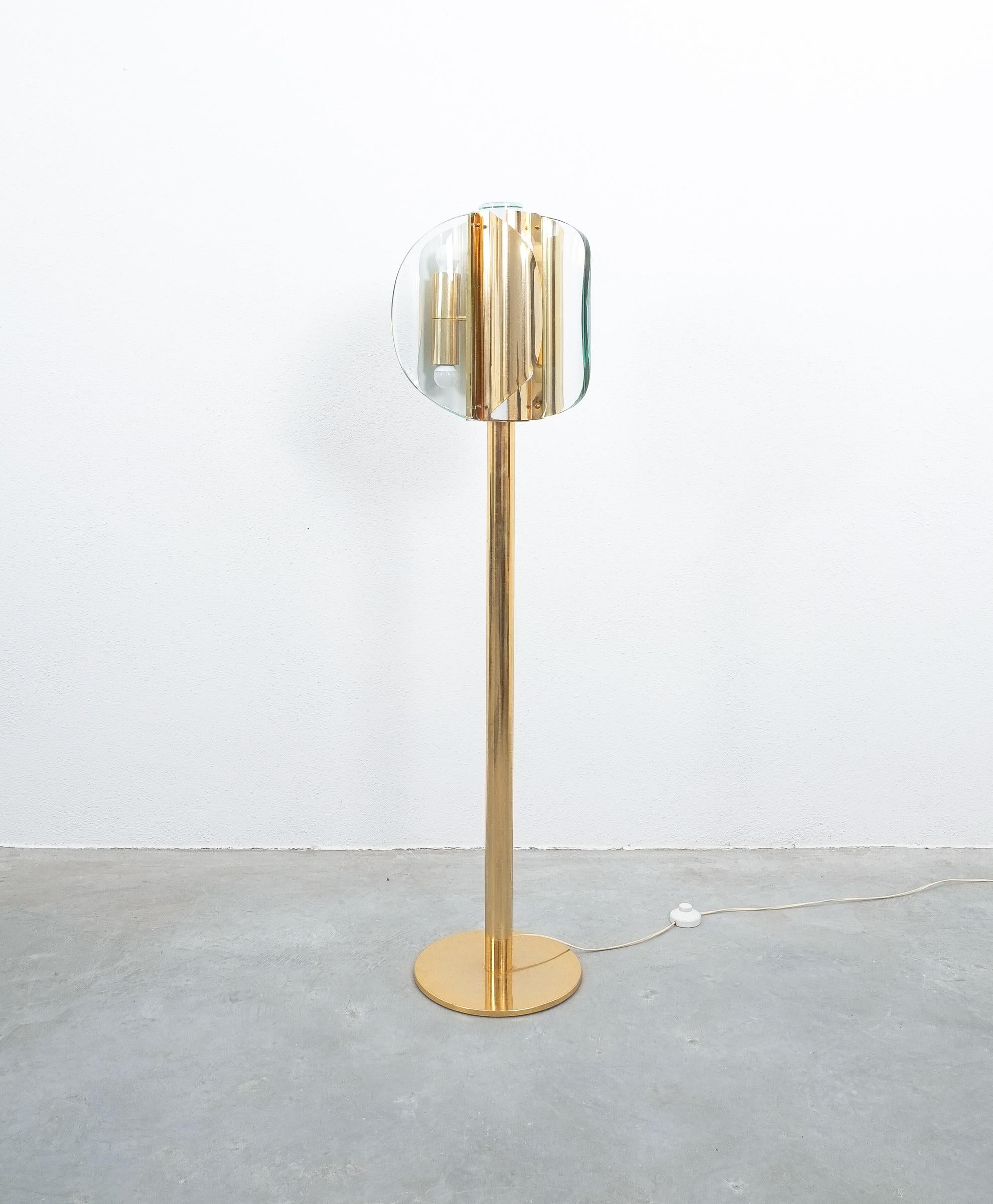 Rare floor lamp style Fontana Arte brass glass, Italy, circa 1965

Rare floor light comprised of brass, curved glass, Italy, 1965. Handmade from three thick curved glass slabs orbiting around a central brass tube. This light has got a total of