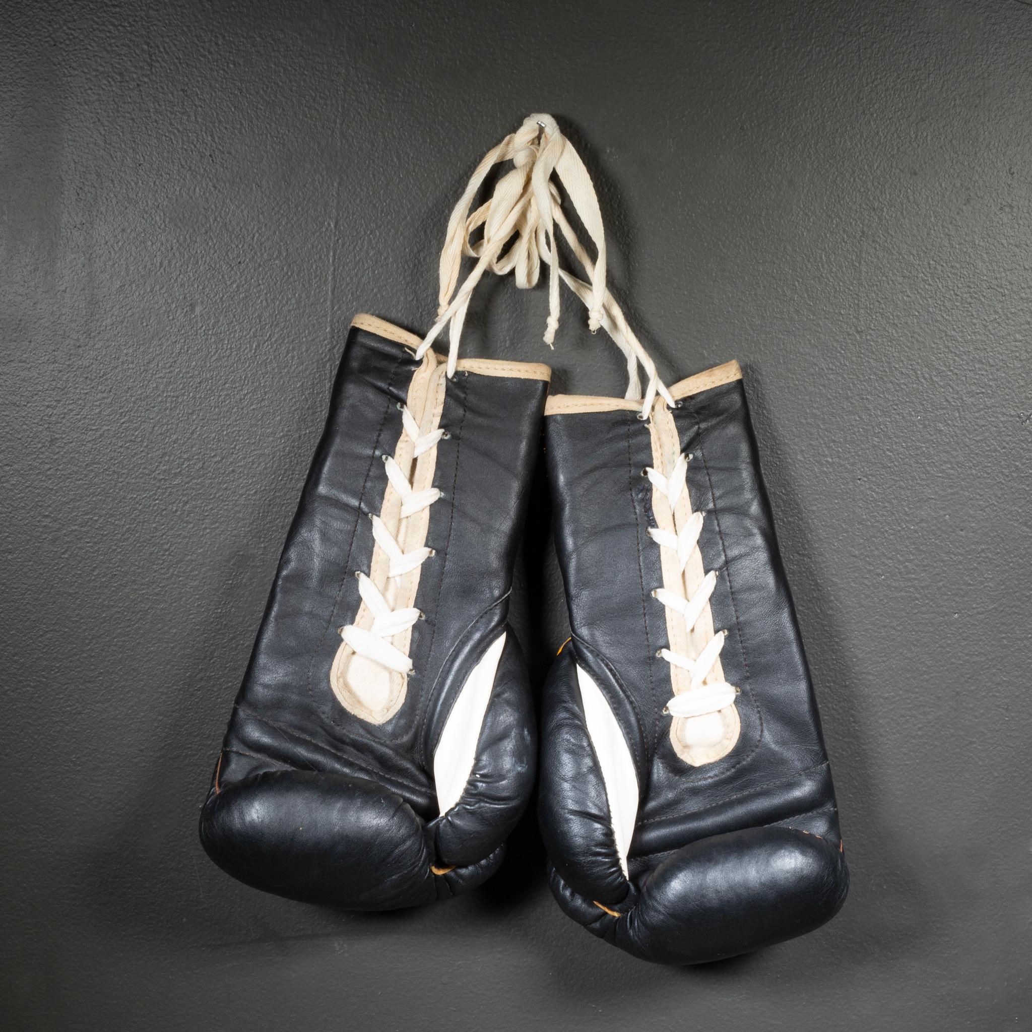 CIRCA

Rari guantoni da boxe Ray Flore in pelle nera con pollici in pelle bianca. Etichetta originale 