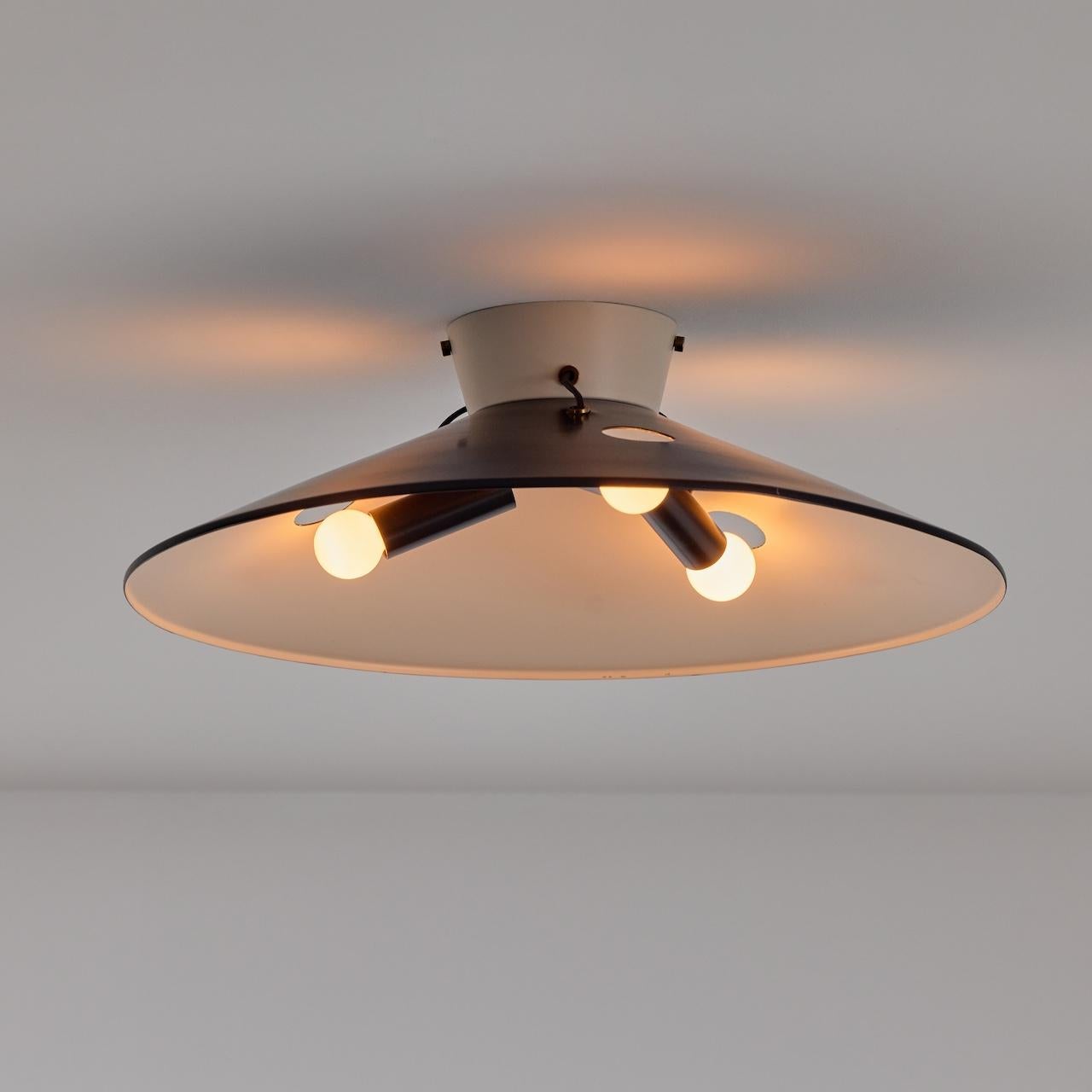 Rare flush mount ceiling lights by Stilnovo. Manufactured in Italy, circa 1950s. Enameled aluminum, black and white. Rewired for U.S standards. We recommend three E14 European candelabra bulbs per light. Bulbs are provided as a one-time courtesy.