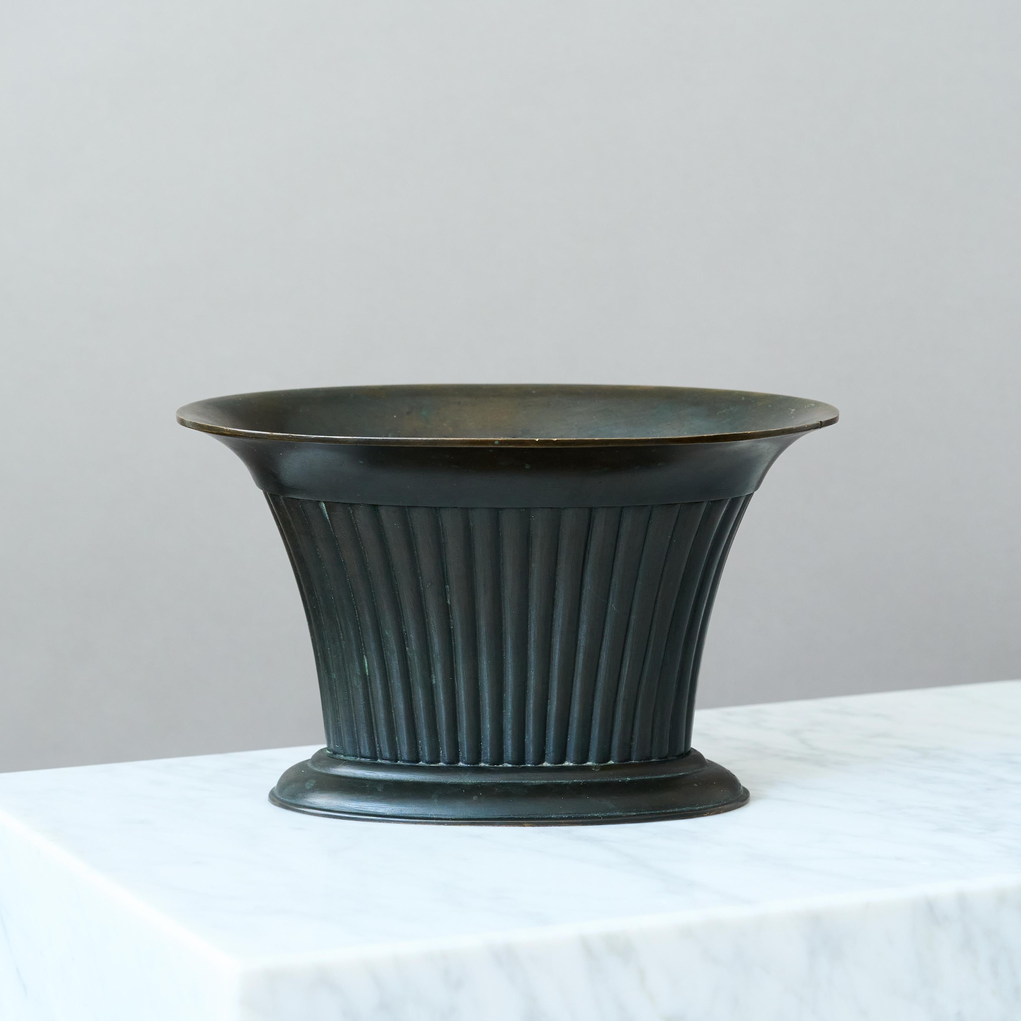 Un raro e bellissimo vaso in bronzo scanalato con inserto traforato e patina sorprendente. 
Fusione realizzata dalla Fonderia Otto Meyer. Svezia, anni '20.

Ottime condizioni, solo qualche leggero graffio.
Timbrata con marchio del produttore e firma
