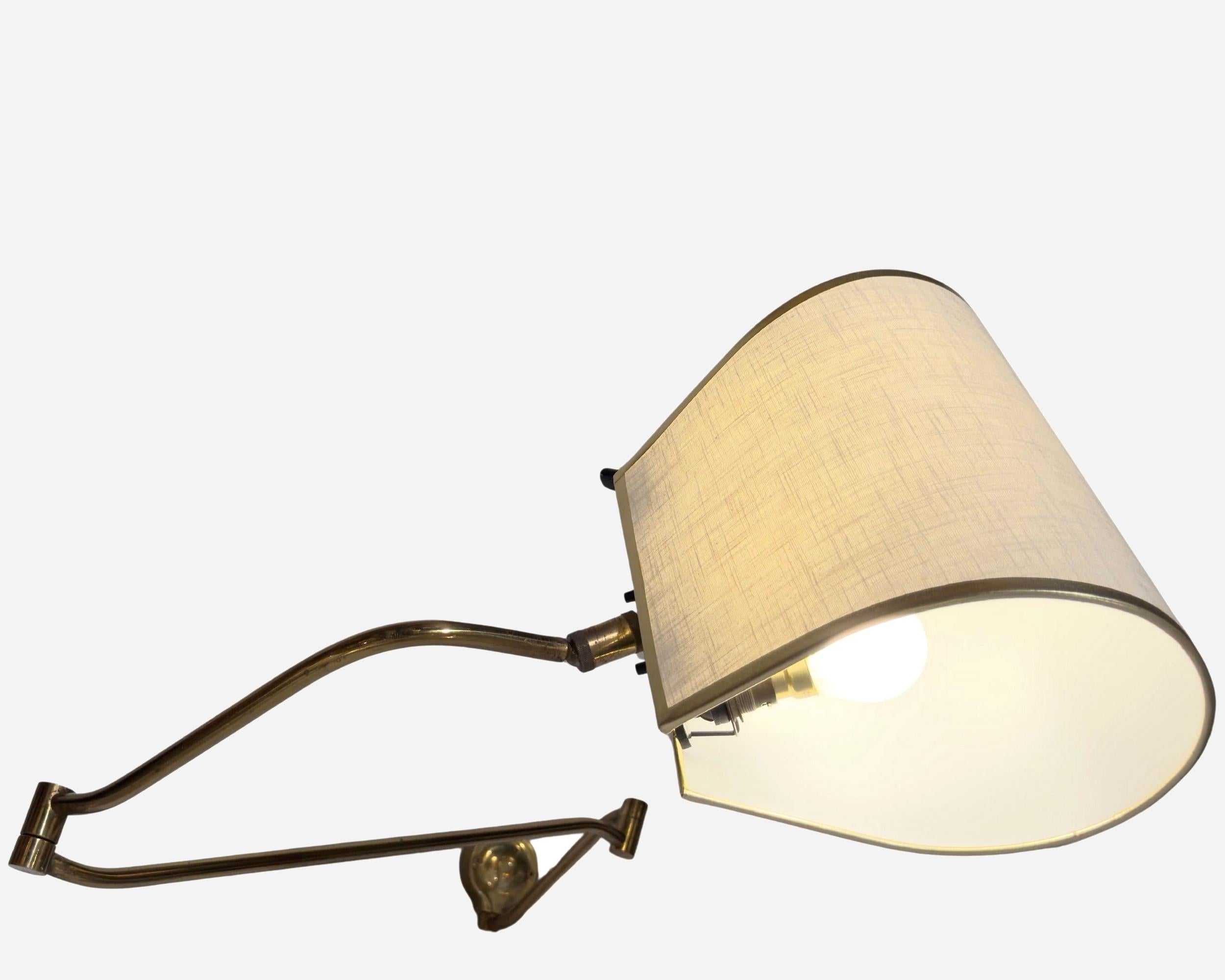 Seltene französische Wandleuchte aus den 1950er Jahren, vollständig an der Wand entlang klappbar.
Der Lichtarm besteht aus drei klappbaren Teilen aus massivem Messing, ebenso wie der Sockel und das Kugelgelenk. Der Schirm kann mit dem Drehgelenk um