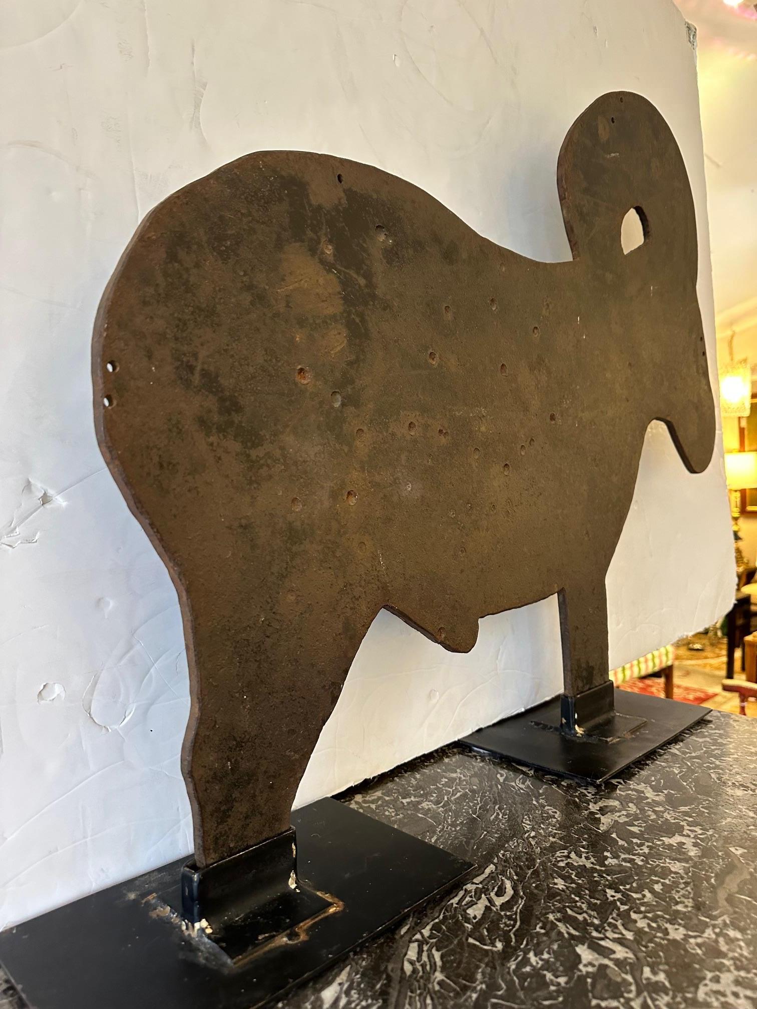Fabulous folk art freestanding animal sculpture made from found carnival art shooting gallery iron ram.  Rich with authentic character, the brown patinated surface is pocked with bullet holes.  Custom black iron stand created to allow the form to be