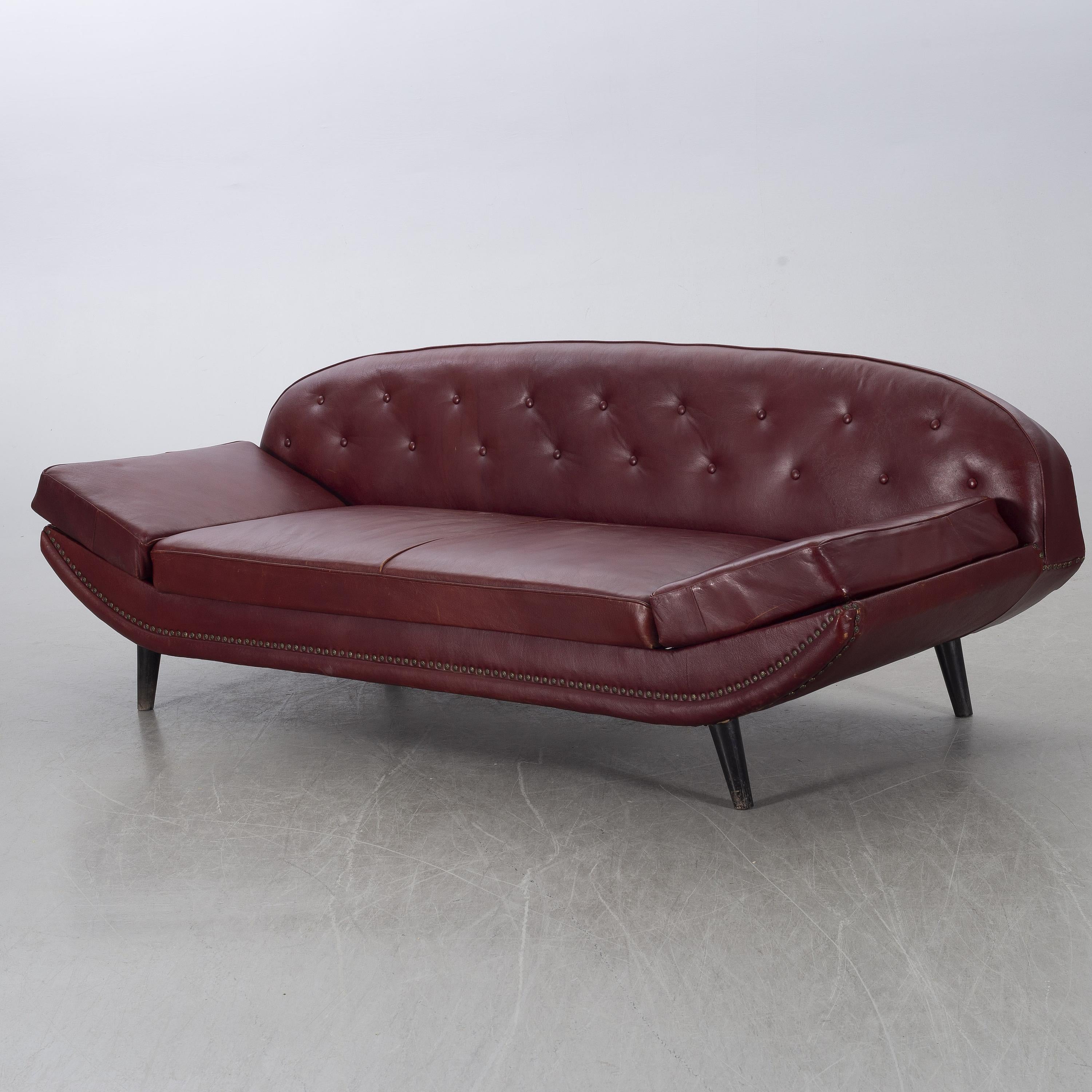 A rare Folke Jansson sofa or daybed produced by SM Wincrantz in Sweden, 1950s. In good structural condition. Signs of wear to vinyl fabric which is why recovering is recomended. If you would like assistance with recovering in your choice of material