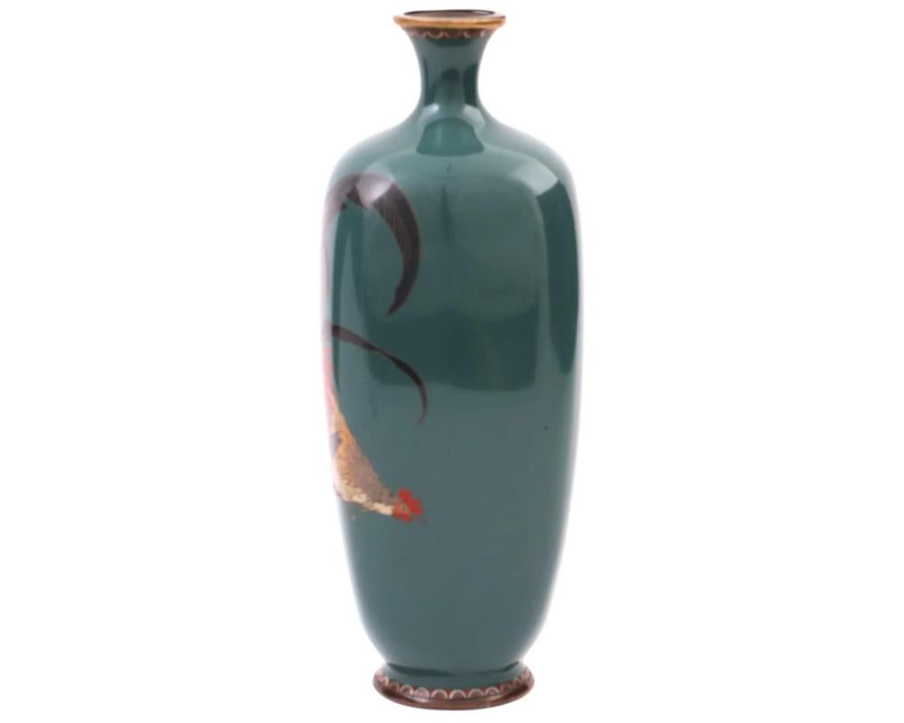 A rare high quality large antique Japanese, late Meiji period, Silver wire and enamel over copper vase. The amphora shaped vase has a narrow fluted neck. The ware is enameled with a polychrome image of a rooster on dark green ground made in the