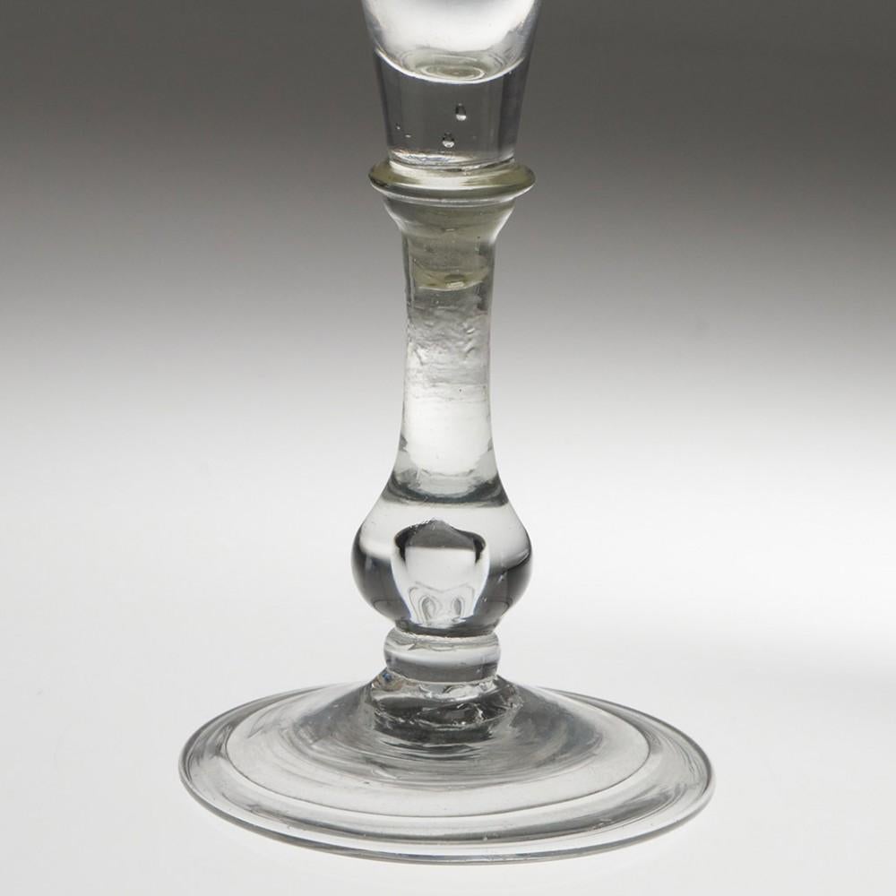 Heading : Rare Form 18th Century Balustroid Wine Glass c1740
Period : George II
Origin : England
Colour : Clear, light grey tome
Bowl : Trumpet shaped
Stem : A blade knop collar above an air beaded baluster knop and flattened ball knop cushion
Foot