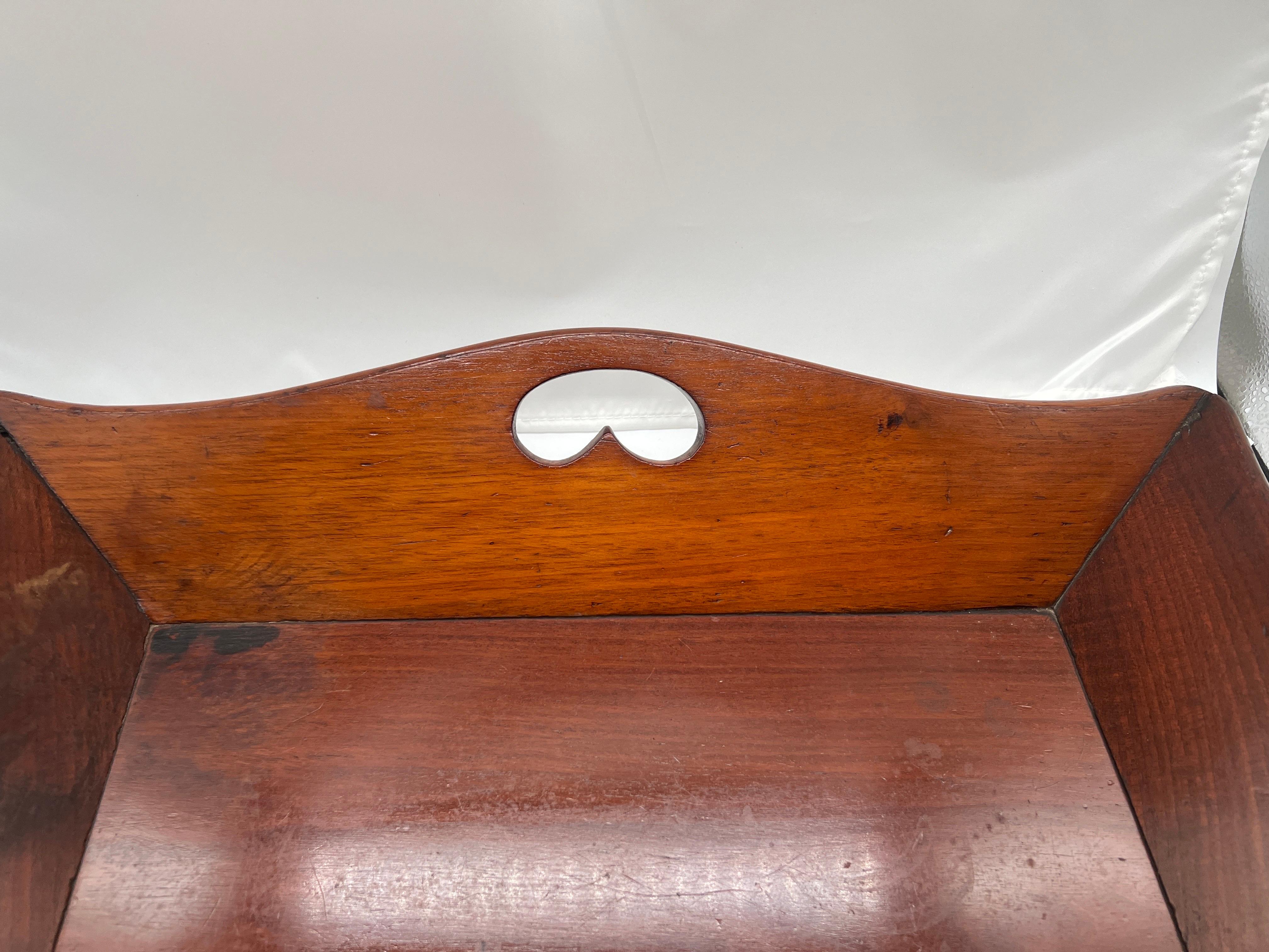 English, late 18th to early 19th century.

This fine quality mahogany tray is a very unusual form. The edges with a scalloped border and cut out handles to each. 

Provenance: From a Newport Rhode Island estate.