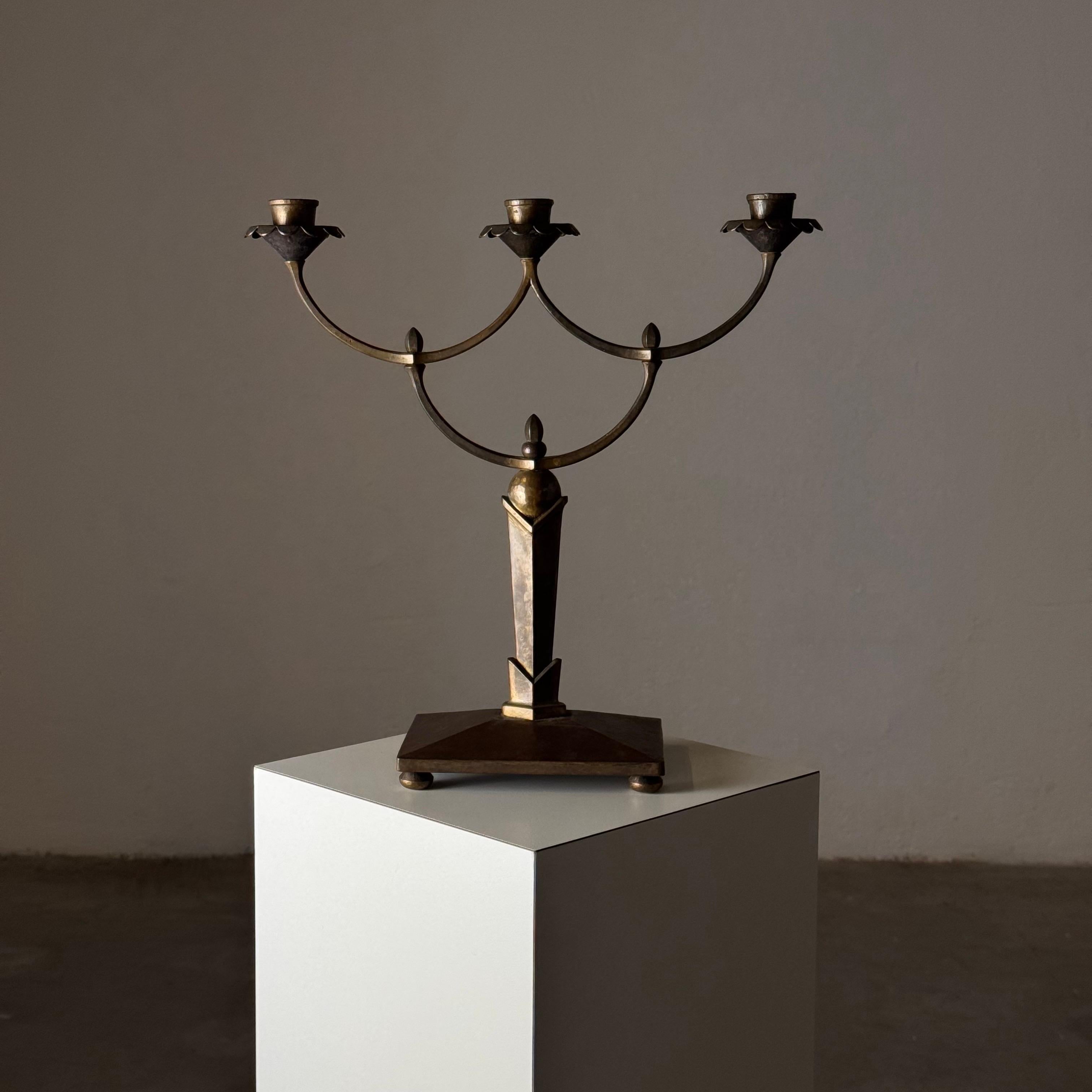 Este extraordinario candelabro, fabricado durante el movimiento de la Secesión austriaca a principios del siglo XX, es un verdadero testimonio de la elegancia y la innovación de su época. Firmada R.S., la pieza es de latón de Sheffield, y luce una