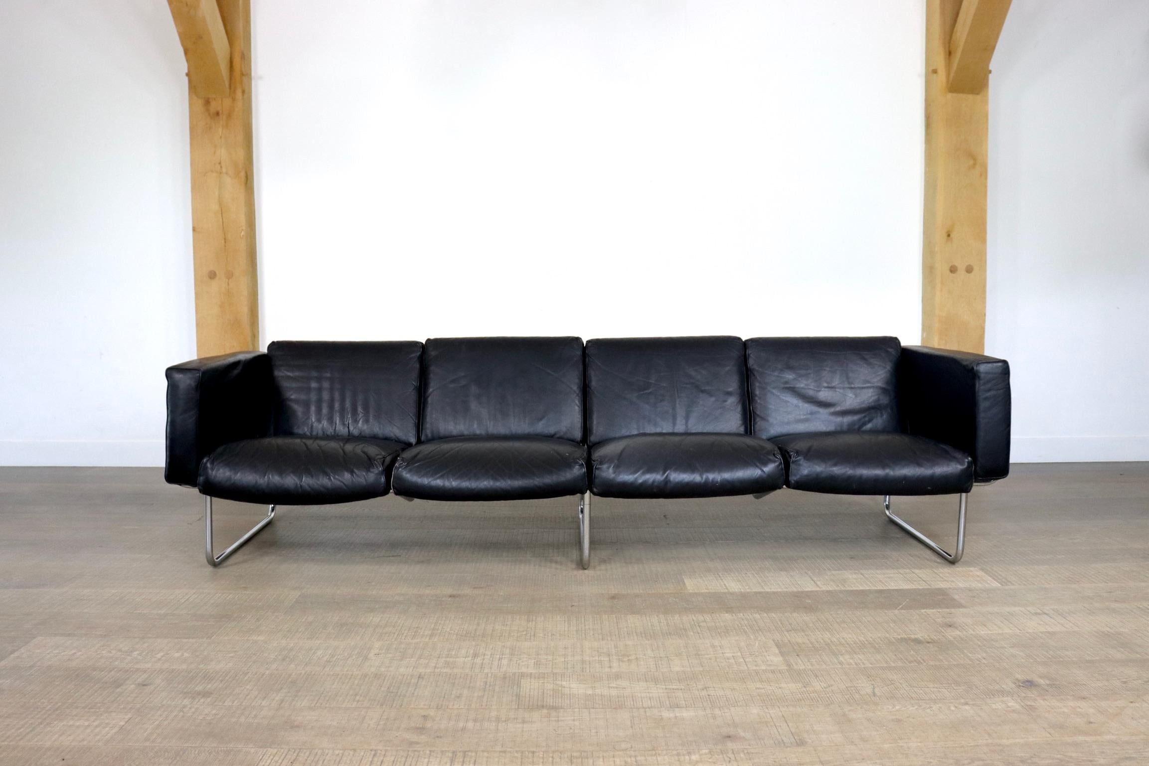 Rare four seater leather by Hans Eichenberger for Strässle, Switzerland 1970s. The stunning chrome tubular frame is supported by 34 springs in the back and 34 in the seating of the sofa for comfort. The original black leather chunky pillows carry a