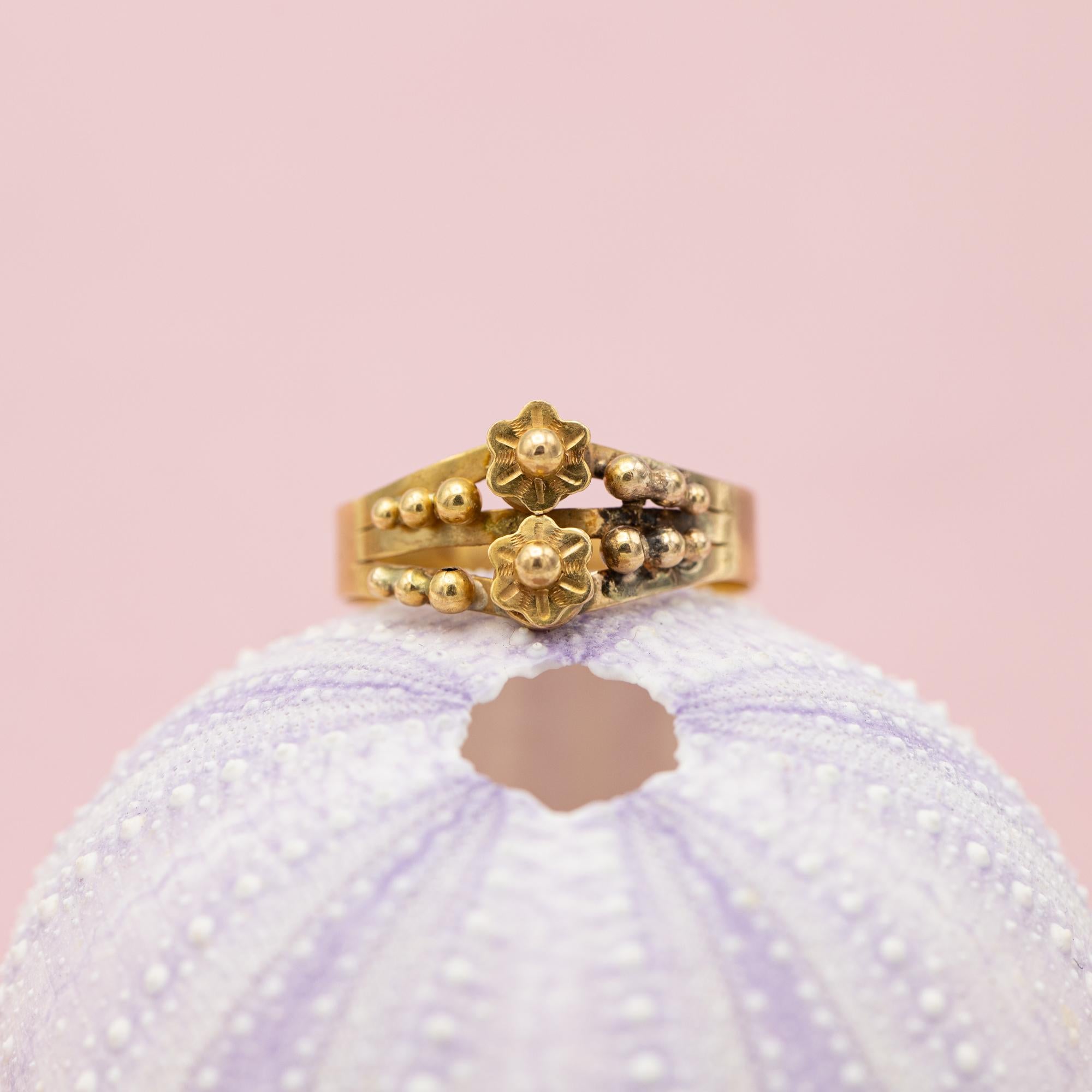 For sale is antique rose gold ring which stole our hearts the minute we laid eyes on her. This marvellous flower ring is made in 18 Karat rose gold and decorated with two flowers and little ball shaped studs.

On top of that this ring is marked with