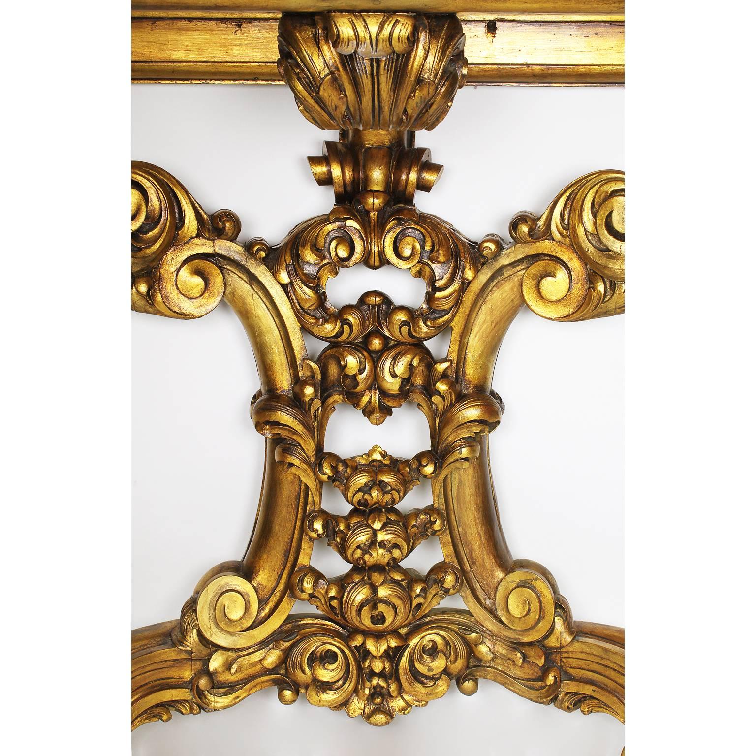 A rare French 19th-20th century Baroque style giltwood carved wall console table with a veined deep burgundy Sarancolin marble top. The 