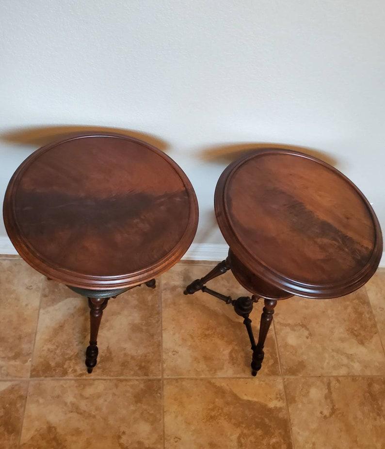 A rare and unusual pair of antique French mahogany round dish-top pedestal side tables. Handcrafted in France in the late 19th - early 20th century, the similarly styled tiered tables feature flame mahogany (crotch - swirl - figured) circular dish