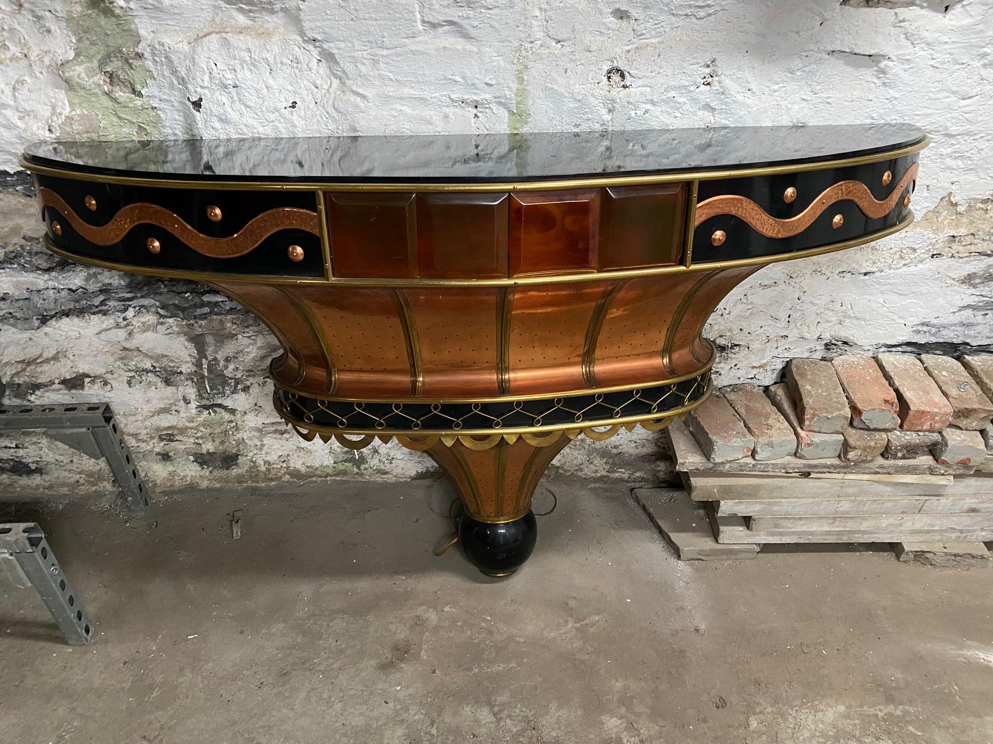 Rare French Art Deco copper and brass demi lune console inset with black lacquered top and with backlight bakelite square. This console was probably a commissioned piece.